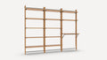 Wooden modular wall-mounted shelving unit with three vertical supports, multiple horizontal shelves, and one fold-down work surface supported by metal brackets.