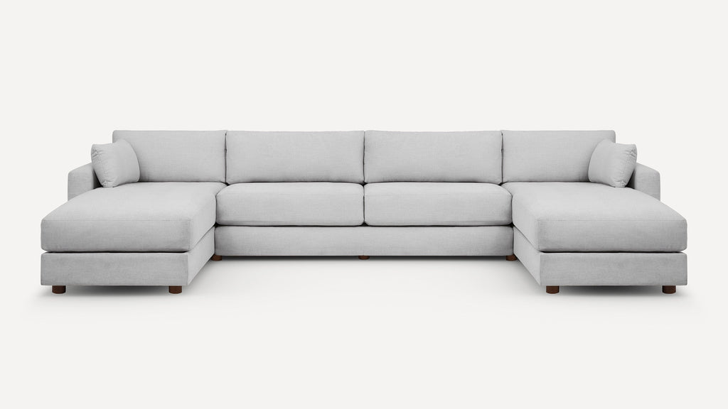 Light grey fabric sectional sofa with one chaise on each end and wooden legs, featuring plush back and side cushions.