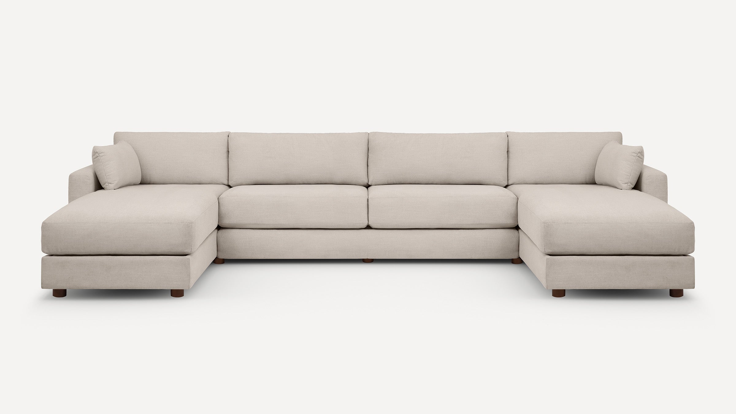 Modern large U-shaped beige sectional sofa with plush cushions and wooden legs, designed for spacious living rooms.