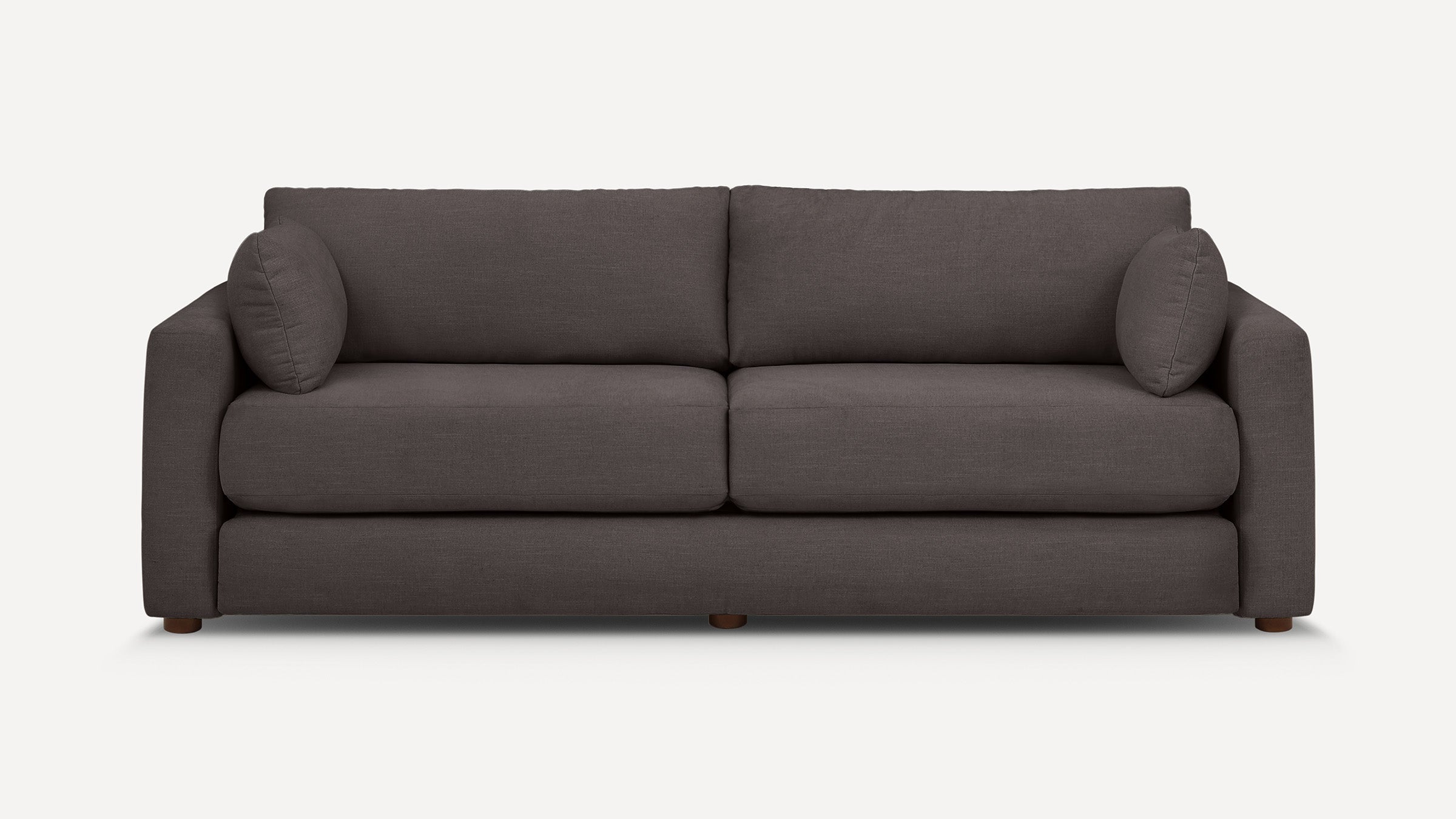 Modern dark gray fabric sofa with straight armrests, two large seat cushions, two back cushions, and two matching round pillows.