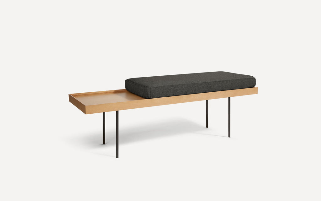 modern wooden bench with black cushion and black metal legs on white background