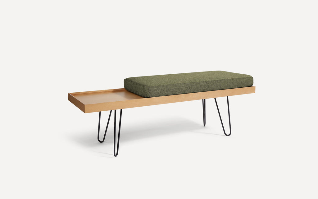 a wooden bench with a green cushion on it