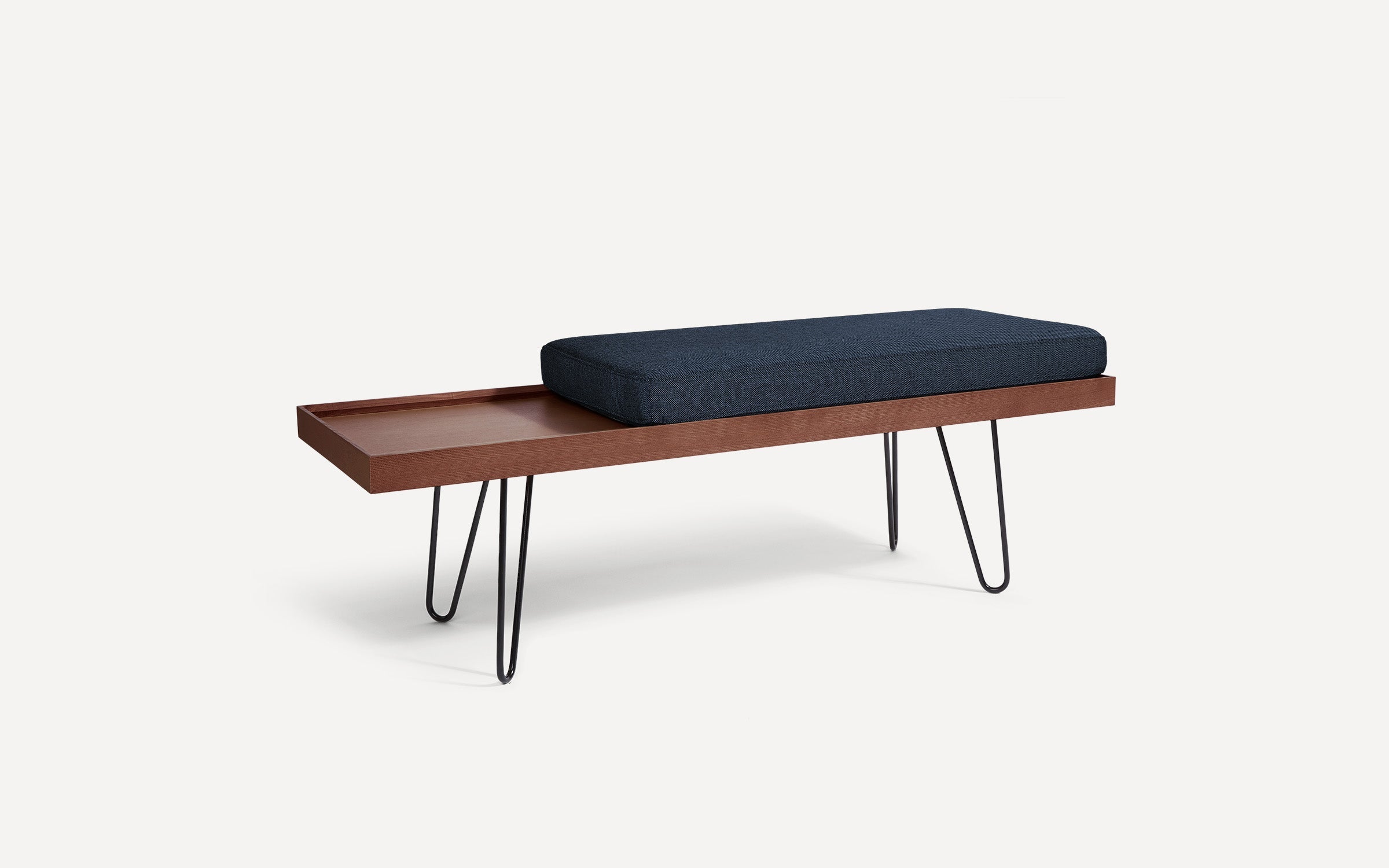 modern wooden bench with black hairpinned legs and a dark blue cushion on top