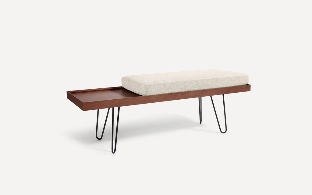 modern wooden bench with a beige upholstered cushion and black hairpinned legs on a white background