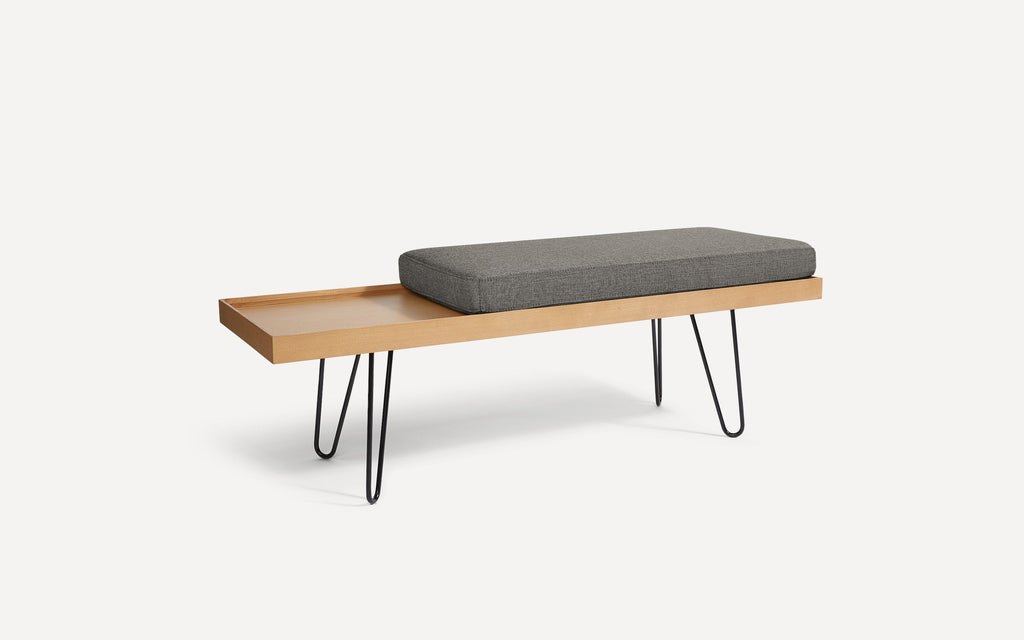 modern wooden bench with black hairpinned legs and a gray cushion on top