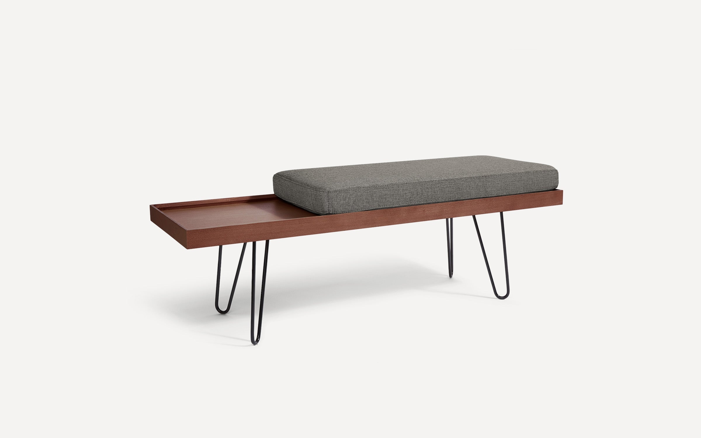 modern wooden bench with gray upholstered cushion and black hairpinned legs on white background