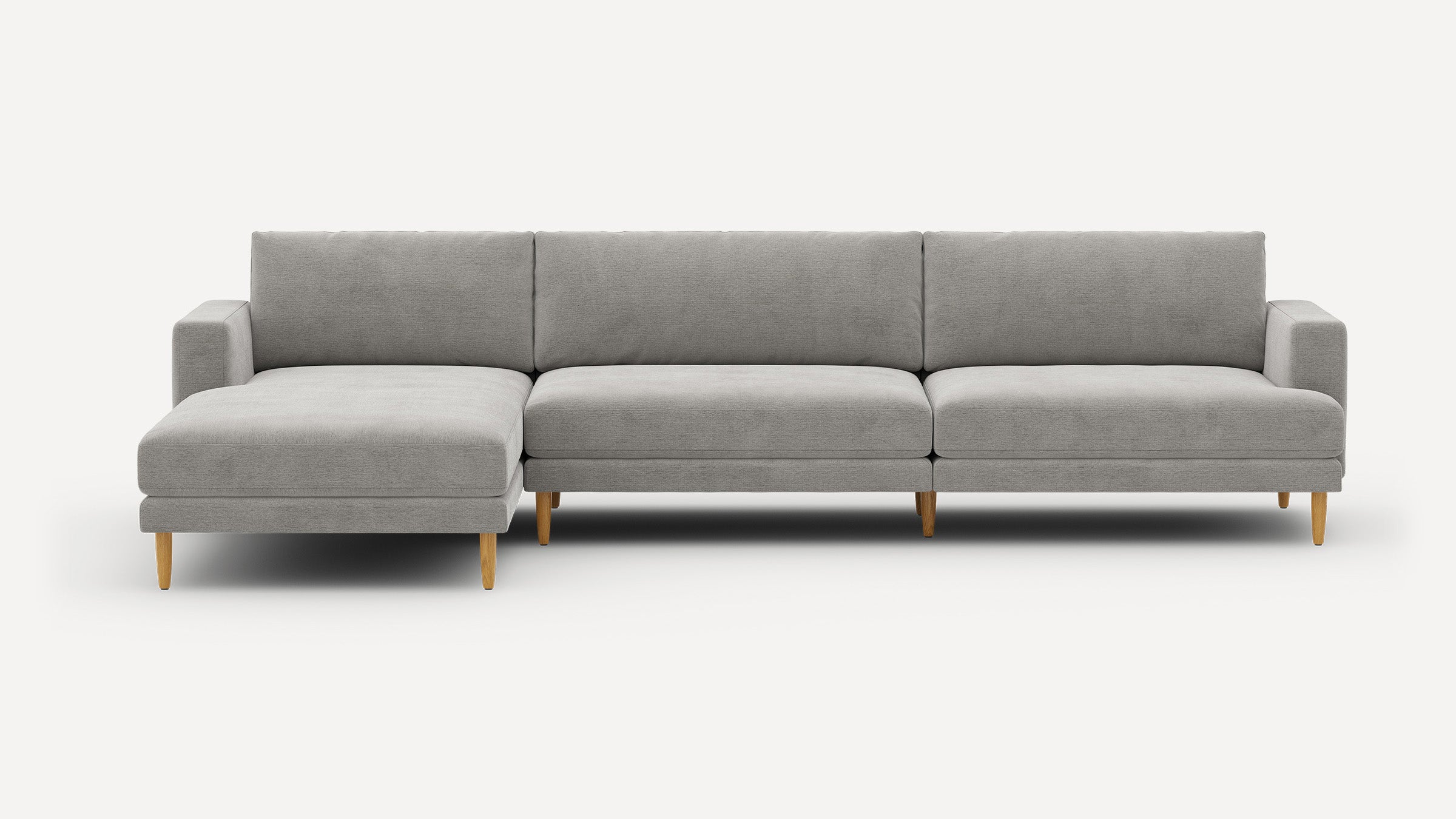 Light grey upholstered sectional sofa with chaise, clean lines, square arms, and wooden tapered legs on a white background.