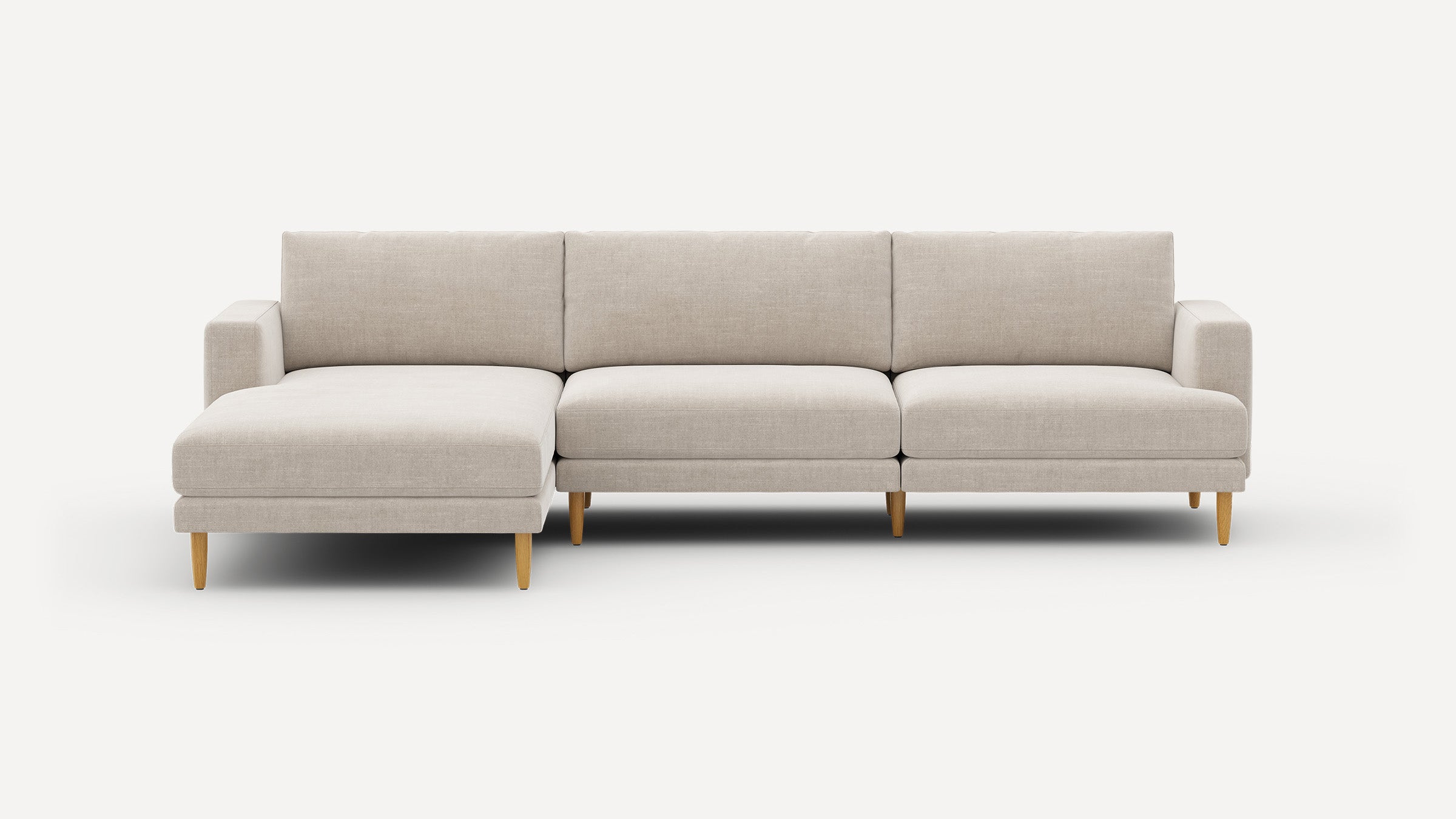 Modern beige sectional sofa with chaise lounge on left side and wooden tapered legs, set against a white background.