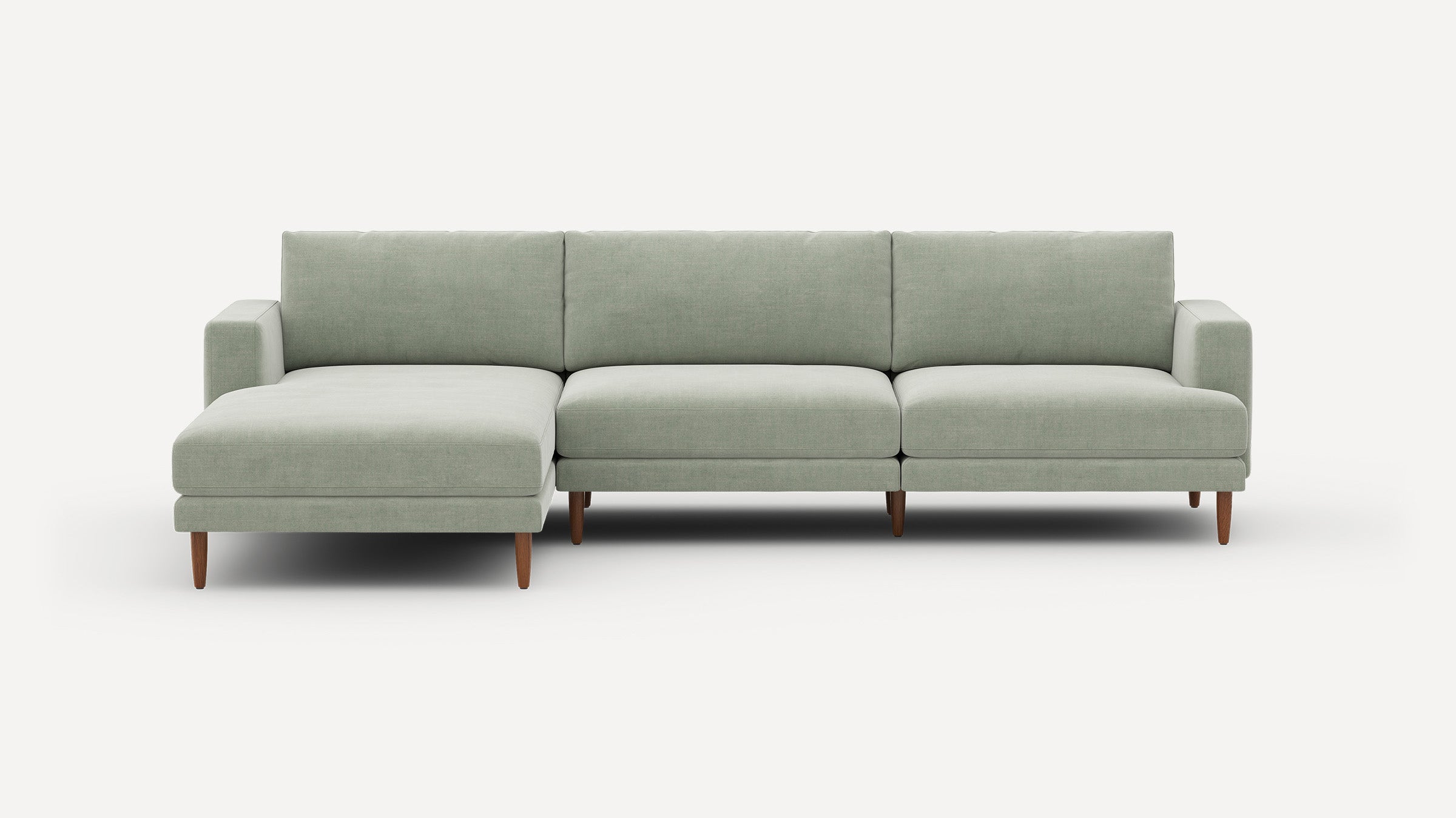 Modern light green sectional sofa with a left chaise, clean lines, and wooden tapered legs on a white background.