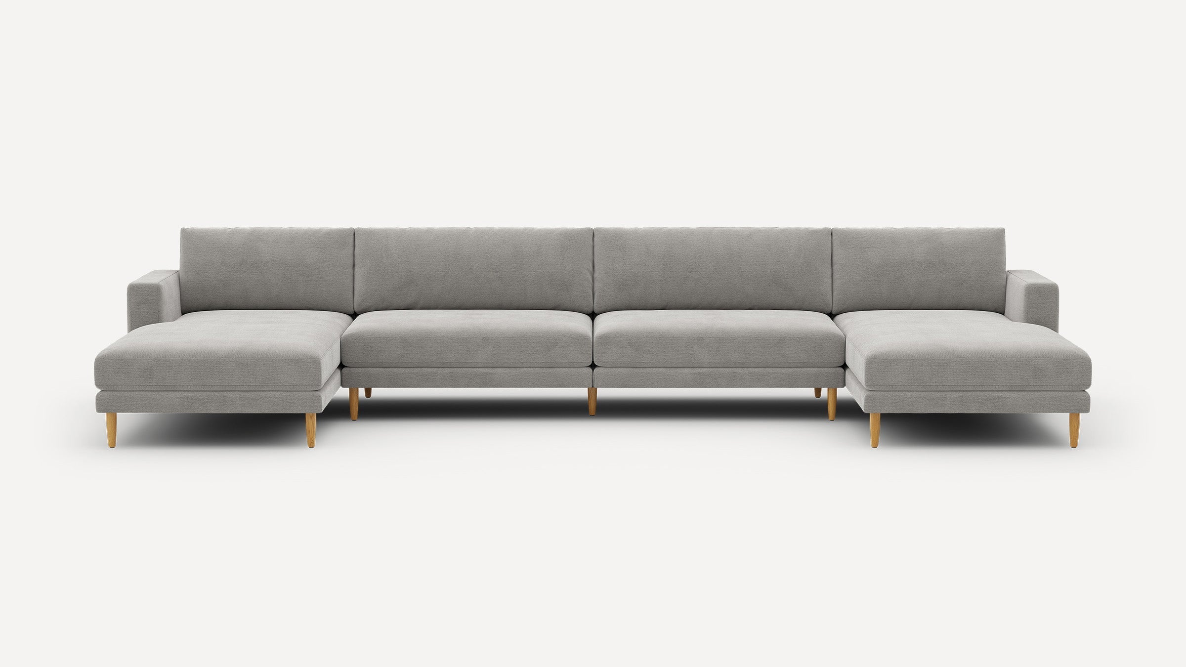 Large modern gray sectional sofa with wooden legs, featuring left and right chaise ends, displayed on white background.