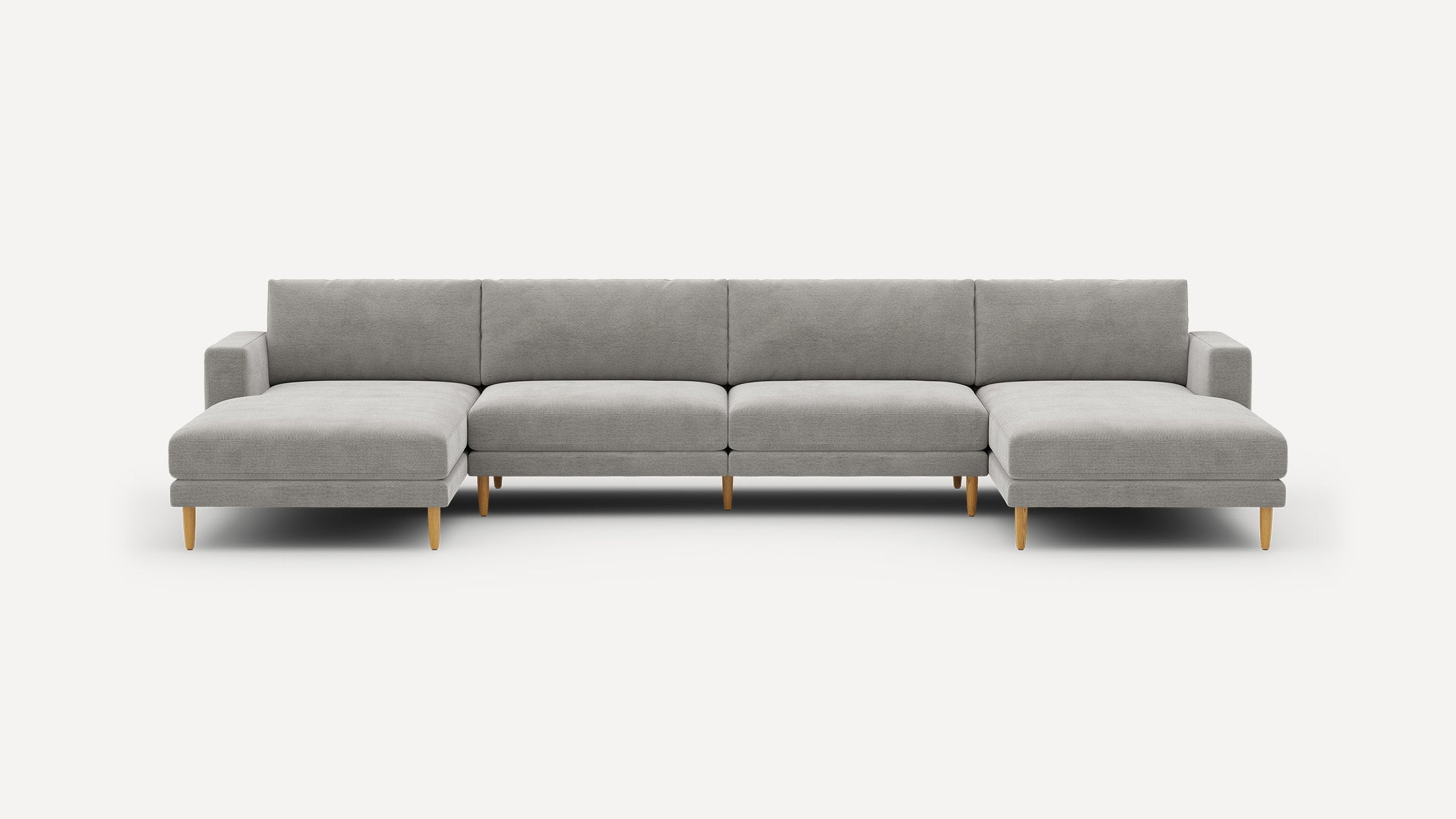 Large modern gray sectional sofa with wooden legs, featuring two chaise ends and a clean, minimalist design.