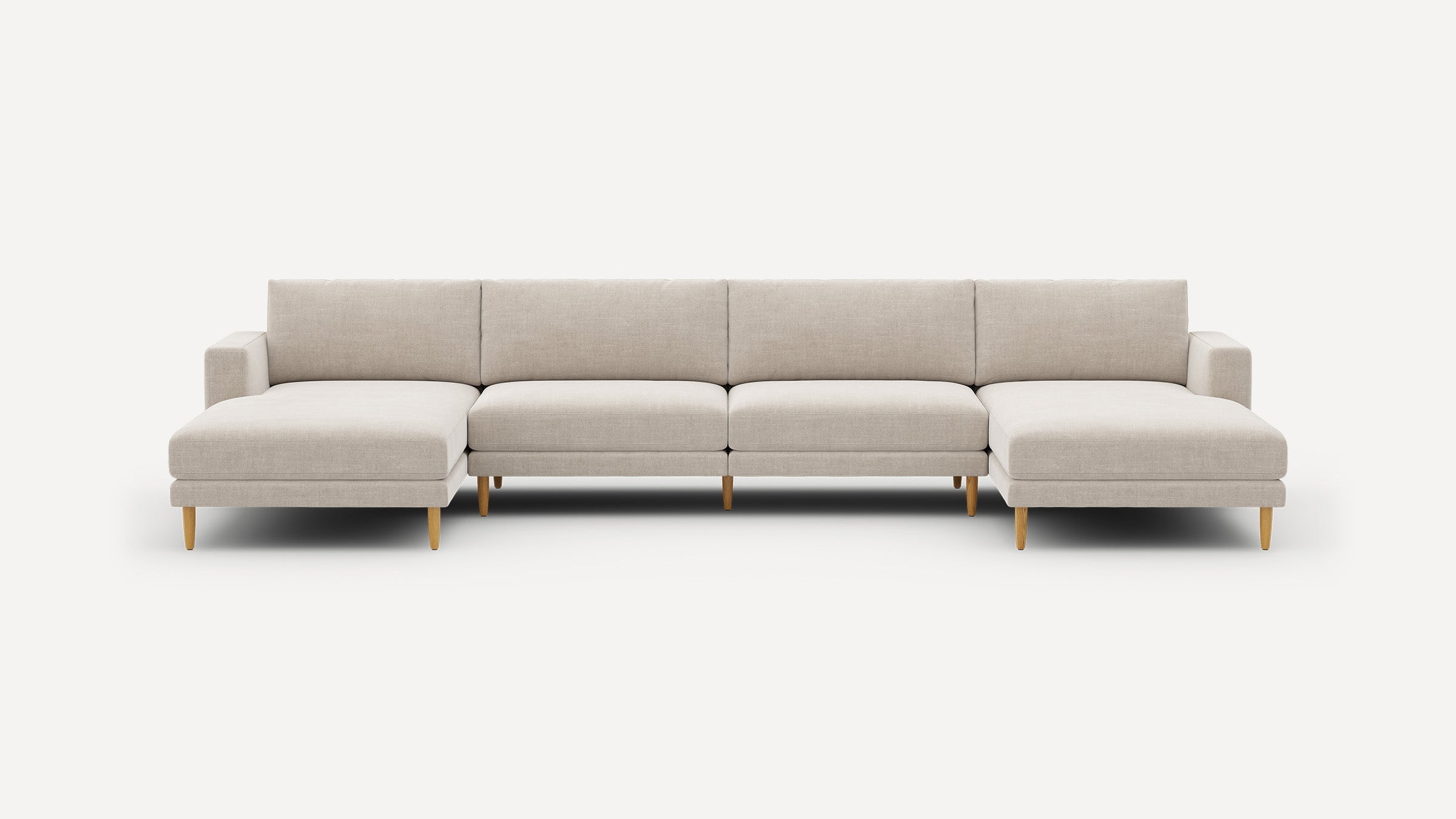 Modern beige fabric sectional sofa with wooden legs, featuring chaise lounges on both ends against a white background.