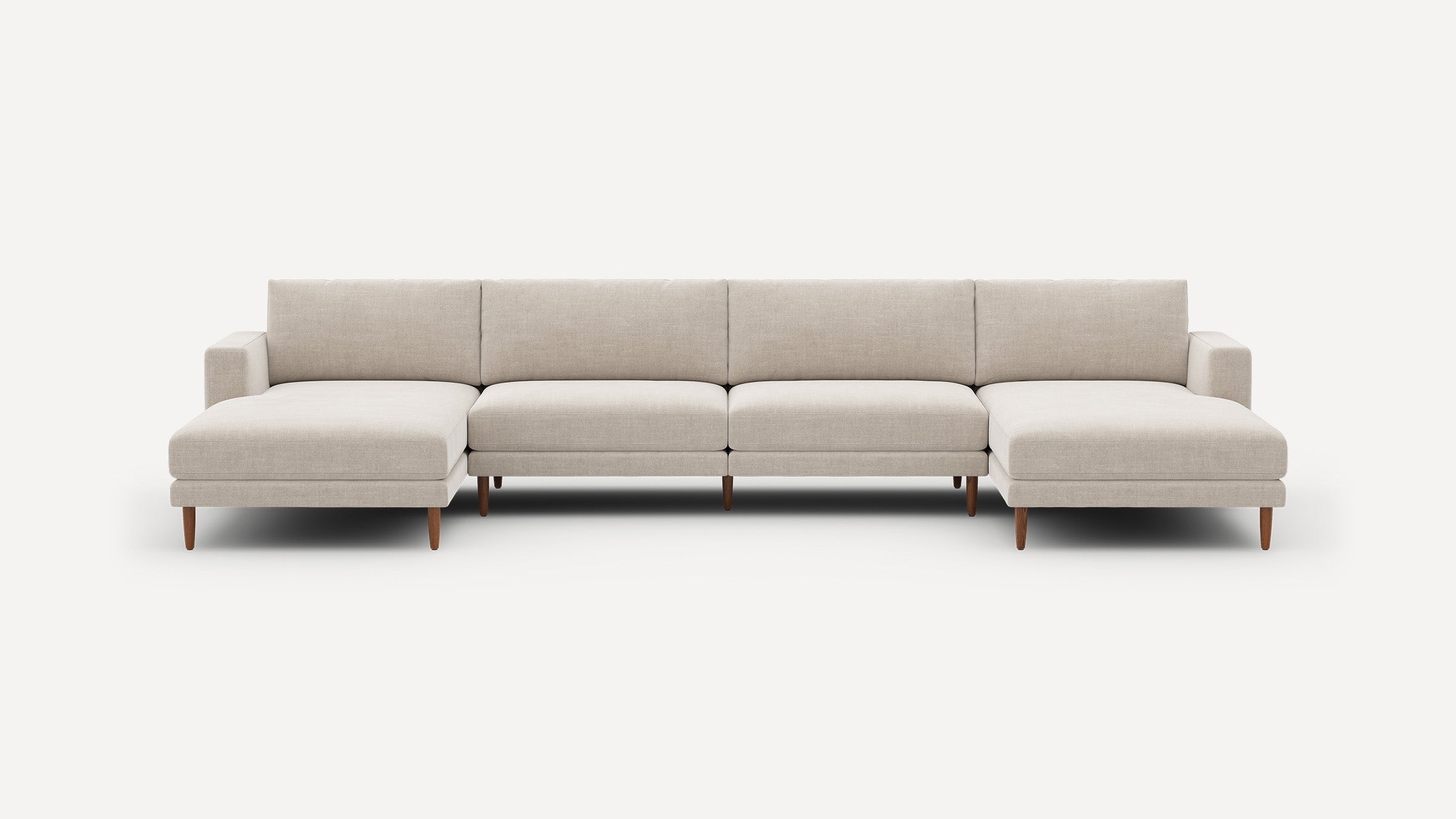 Modern beige fabric sectional sofa with clean lines, wooden legs, and two chaise ends against a white background.