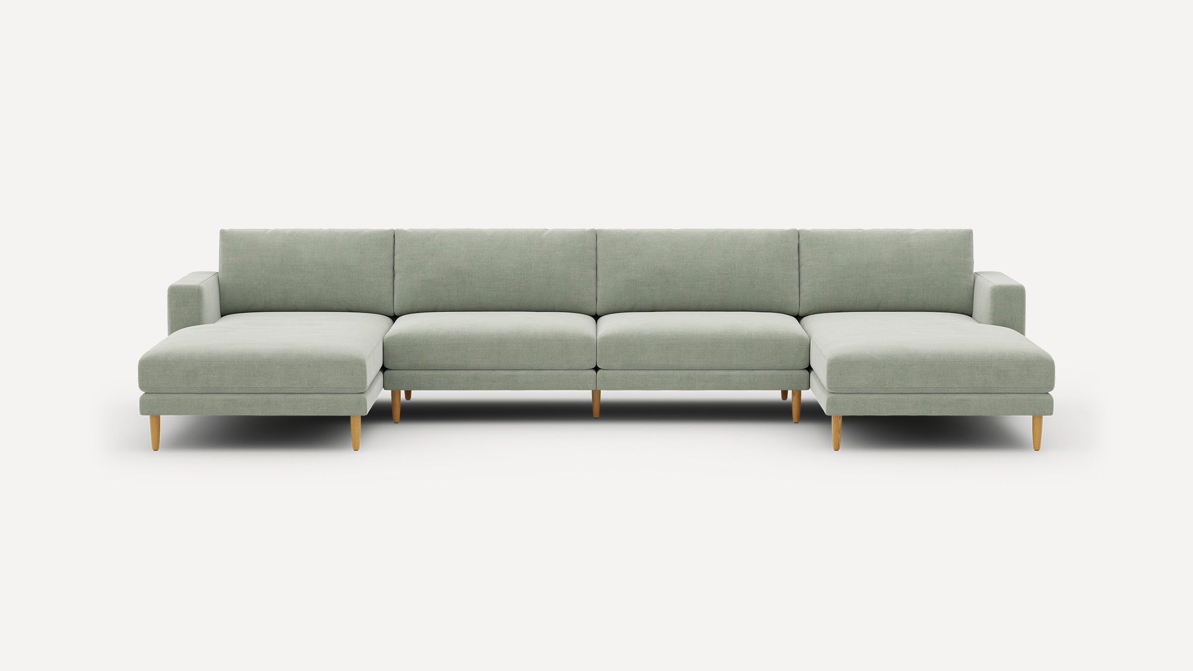 Modern light gray sectional sofa with chaise lounges on both ends and wooden tapered legs against white background.