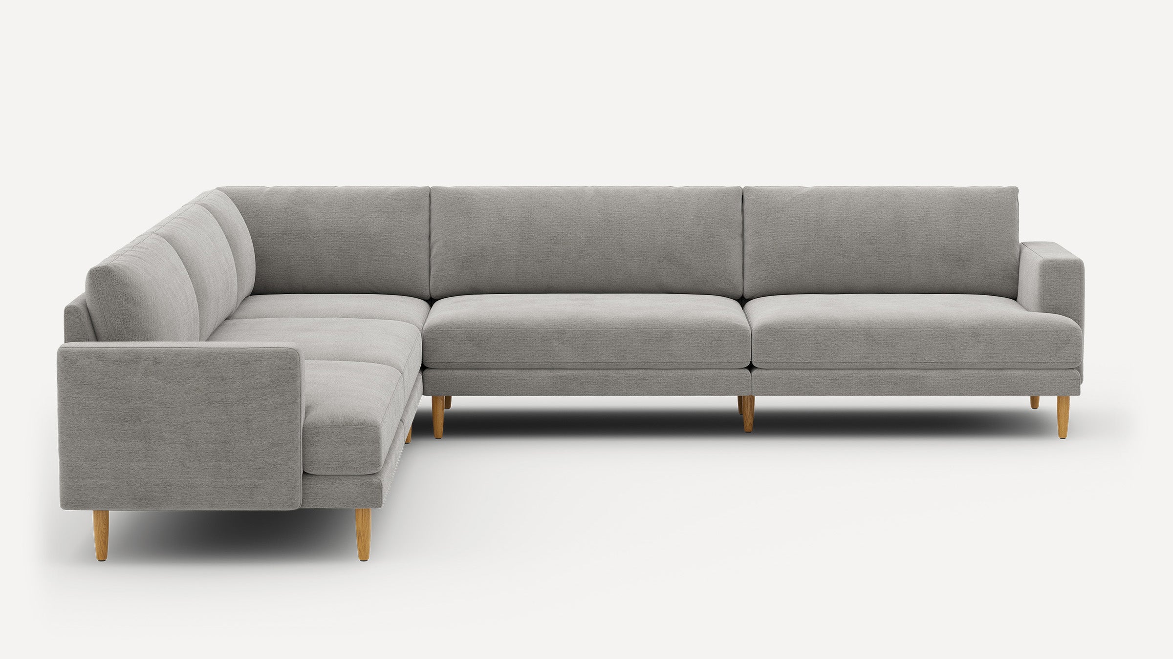 Modern L-shaped sectional sofa with light grey fabric upholstery and wooden tapered legs against white background.
