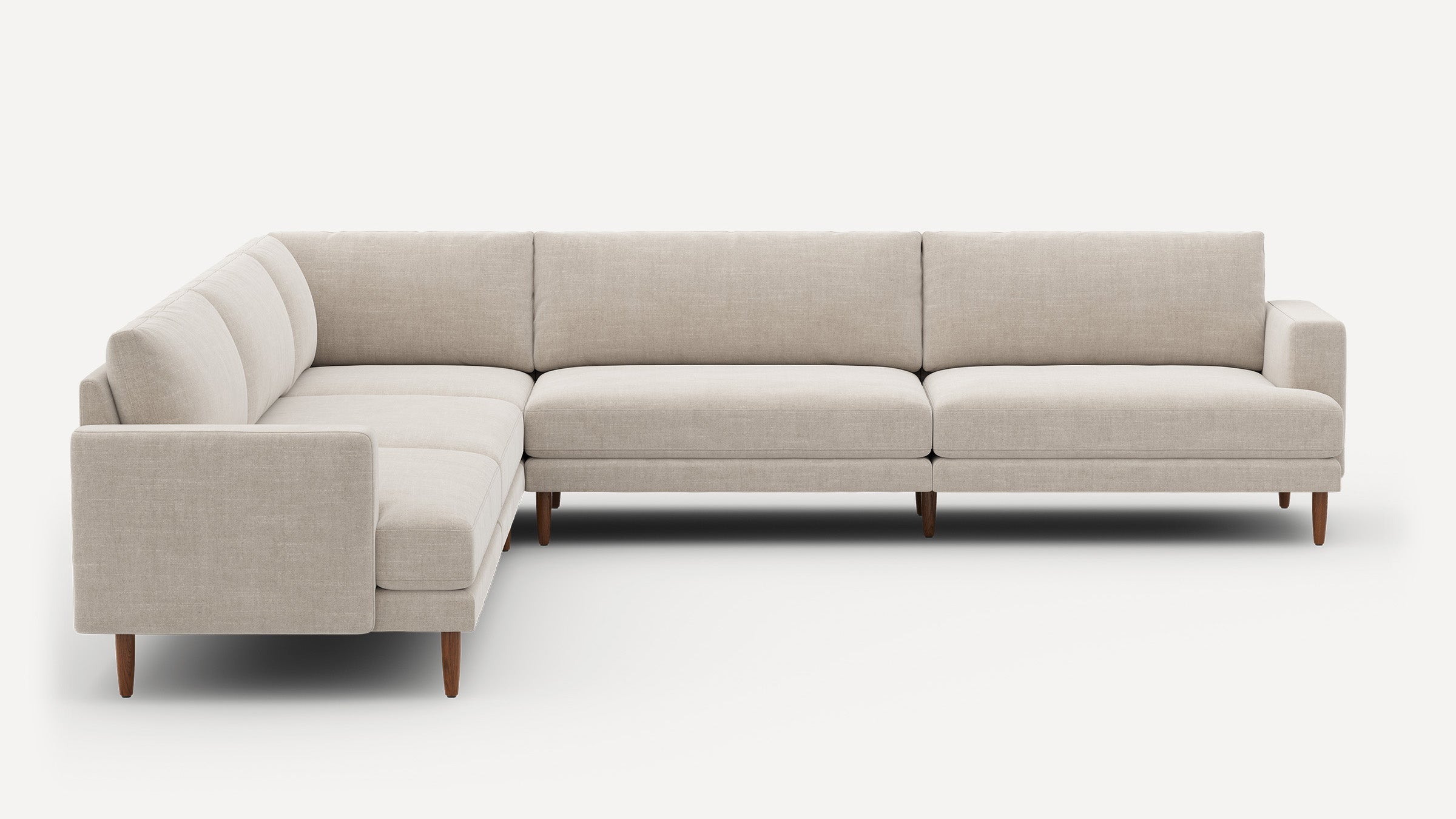Beige L-shaped sectional sofa with clean lines, wooden tapered legs, and plush cushions against a white background.