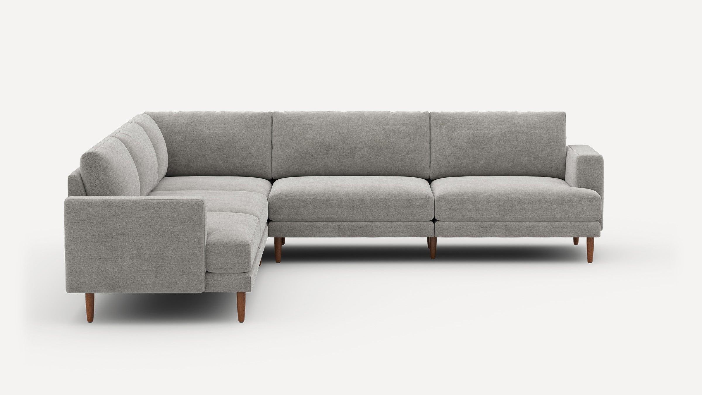 Modern L-shaped sectional sofa with light grey fabric upholstery and tapered wooden legs, designed for spacious seating.