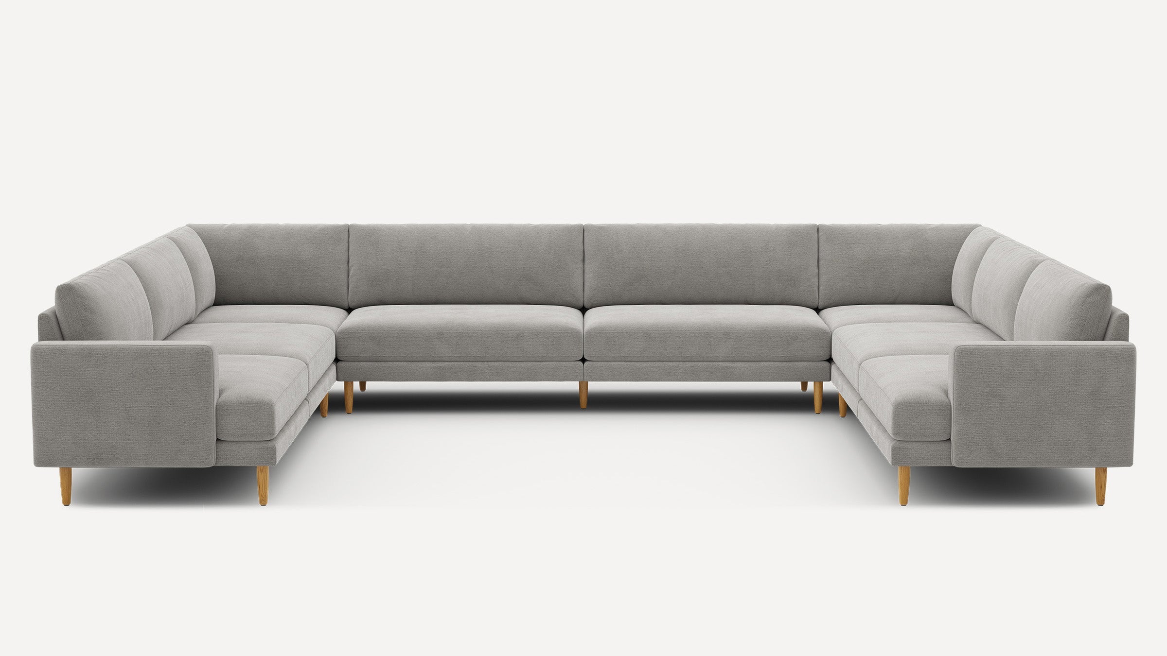 Large modern U-shaped sectional sofa in light gray fabric with clean lines and wooden legs.