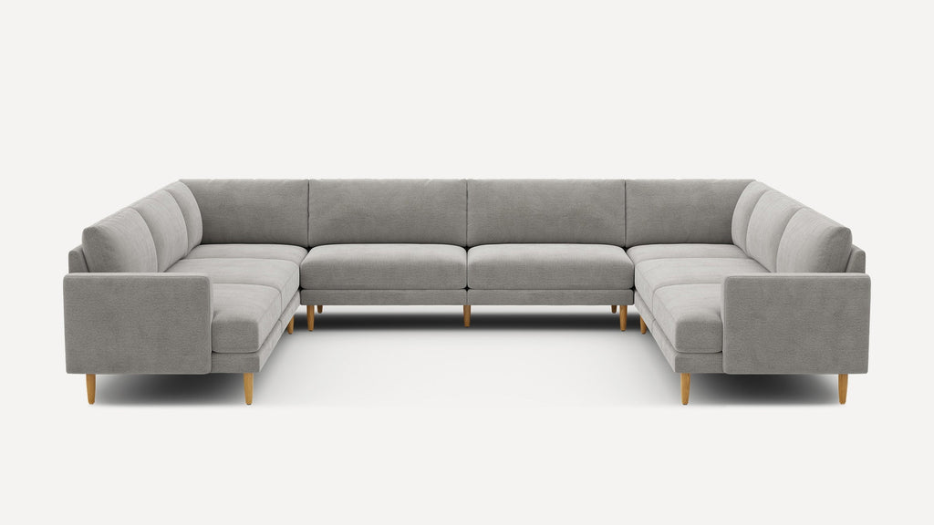 Modern gray U-shaped sectional sofa with clean lines, cushioned seats, supportive backrests, and light wooden tapered legs on a white background.