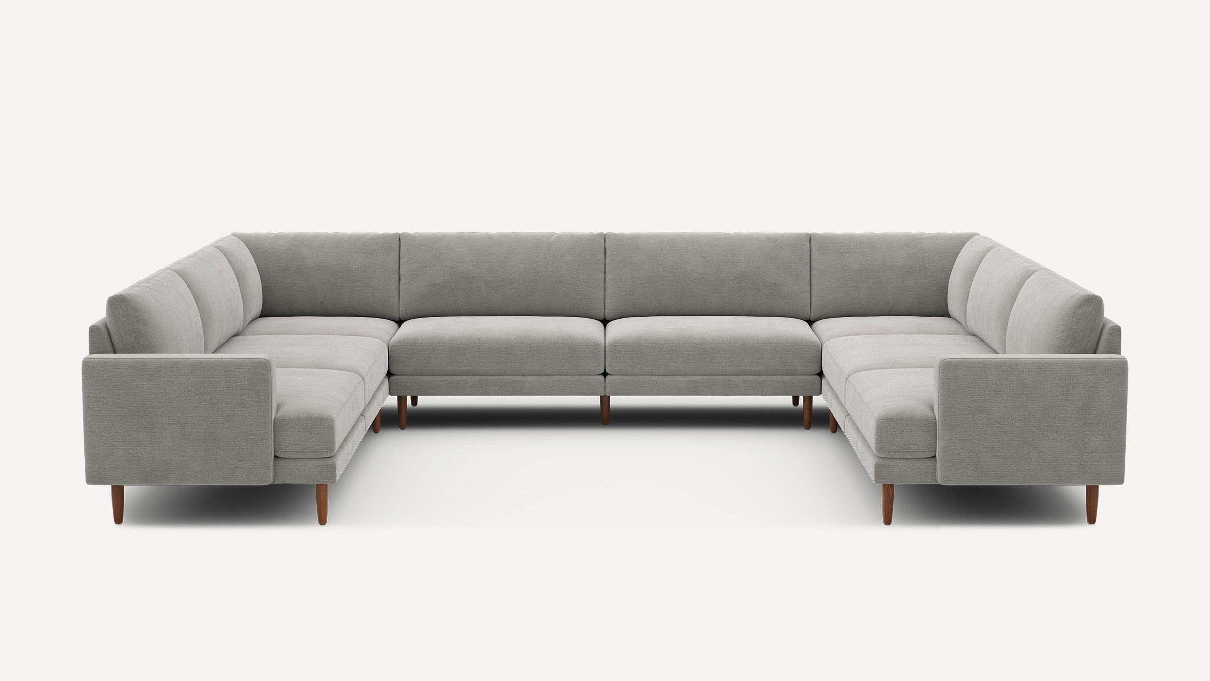 Large gray fabric sectional sofa with wooden legs, modern design, and deep cushions, arranged in a U-shape.