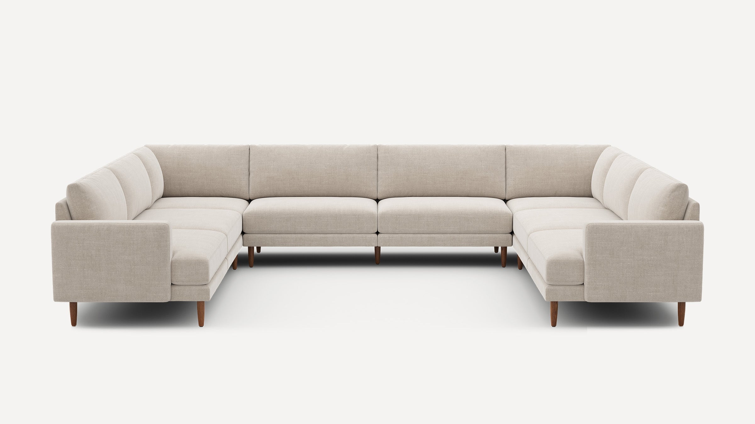 Large U-shaped beige fabric sectional sofa with wooden tapered legs, modern design, and cushioned seats and backrests.