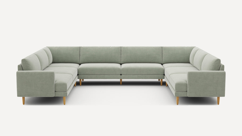 Large U-shaped sectional sofa with light gray upholstery and wooden tapered legs, designed for spacious modern living rooms.