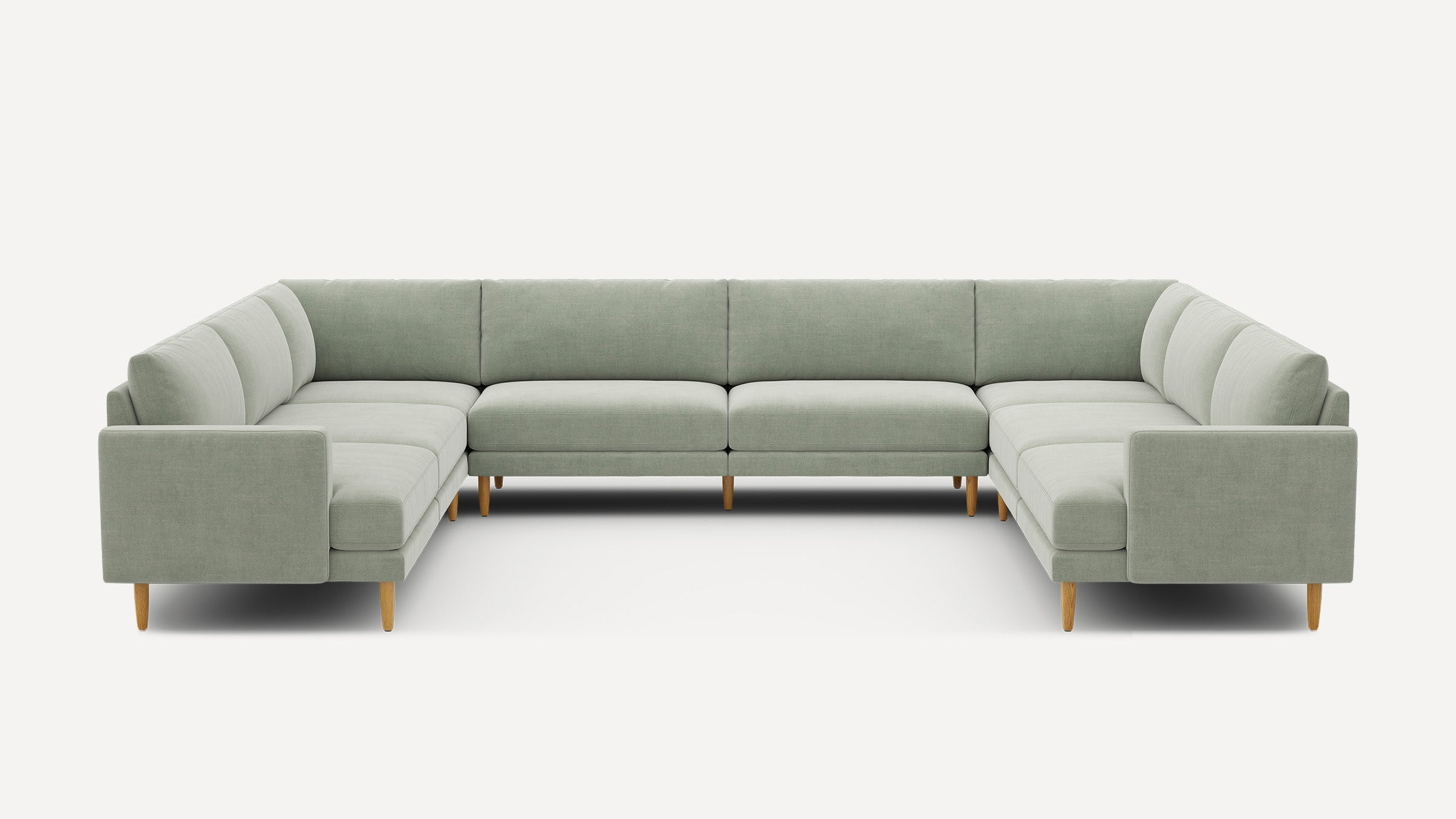Large U-shaped sectional sofa with light gray upholstery and wooden tapered legs, designed for spacious modern living rooms.