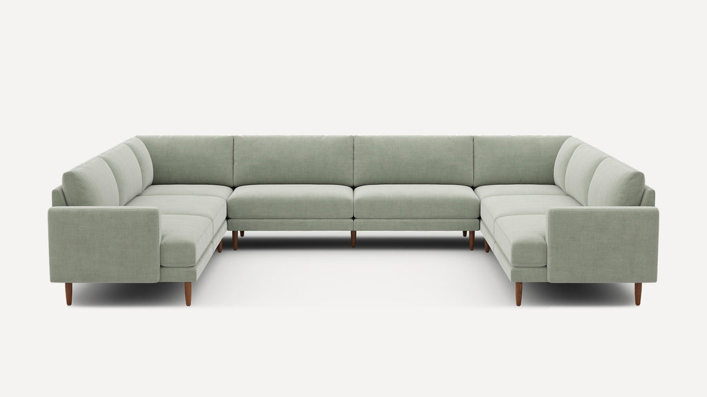 Large U-shaped sectional sofa with light gray upholstery and wooden legs, featuring clean lines and a modern minimalist design.