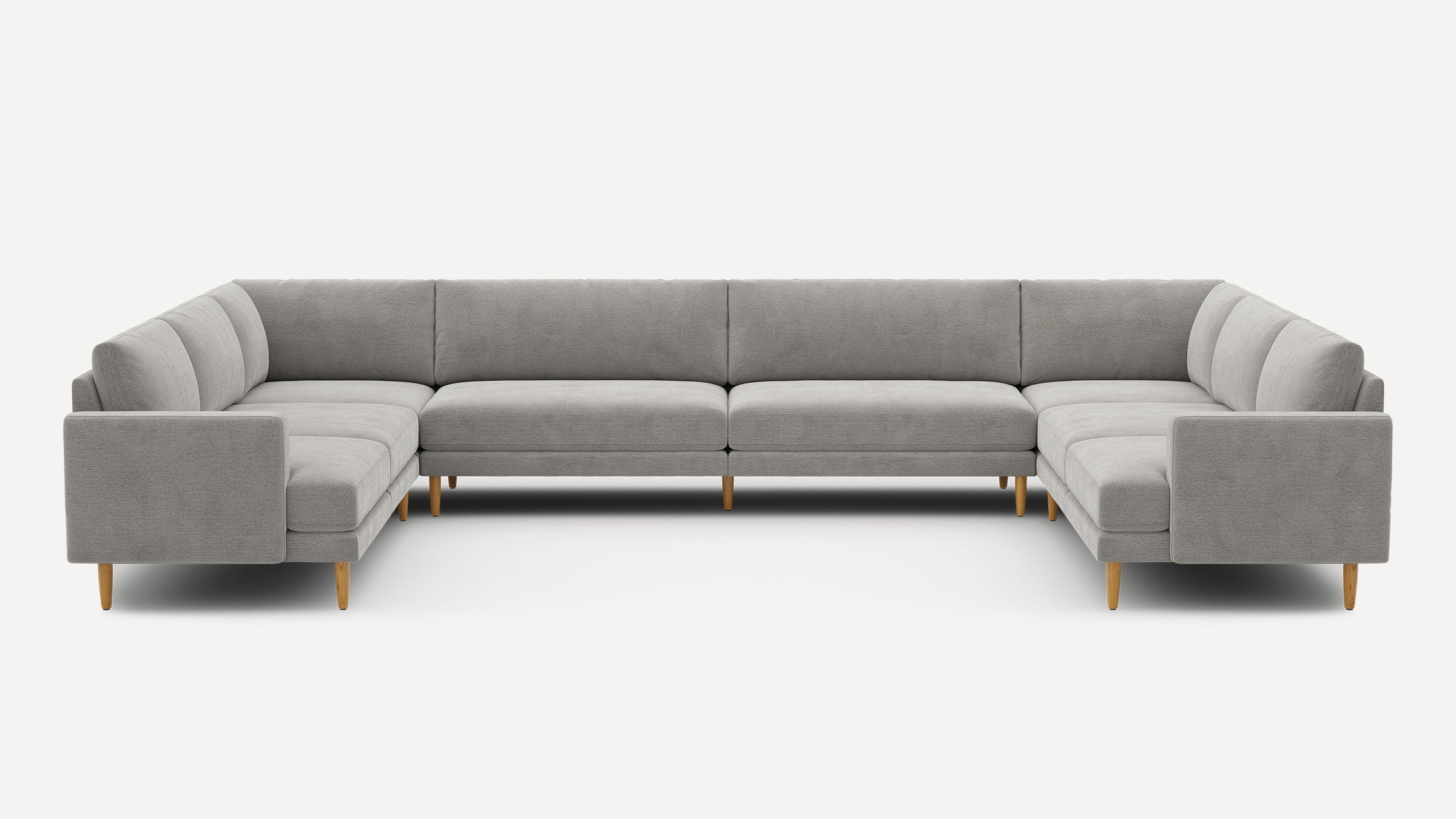 Large U-shaped sectional sofa with light gray upholstery and wooden legs, featuring clean modern lines and cushioned seating.