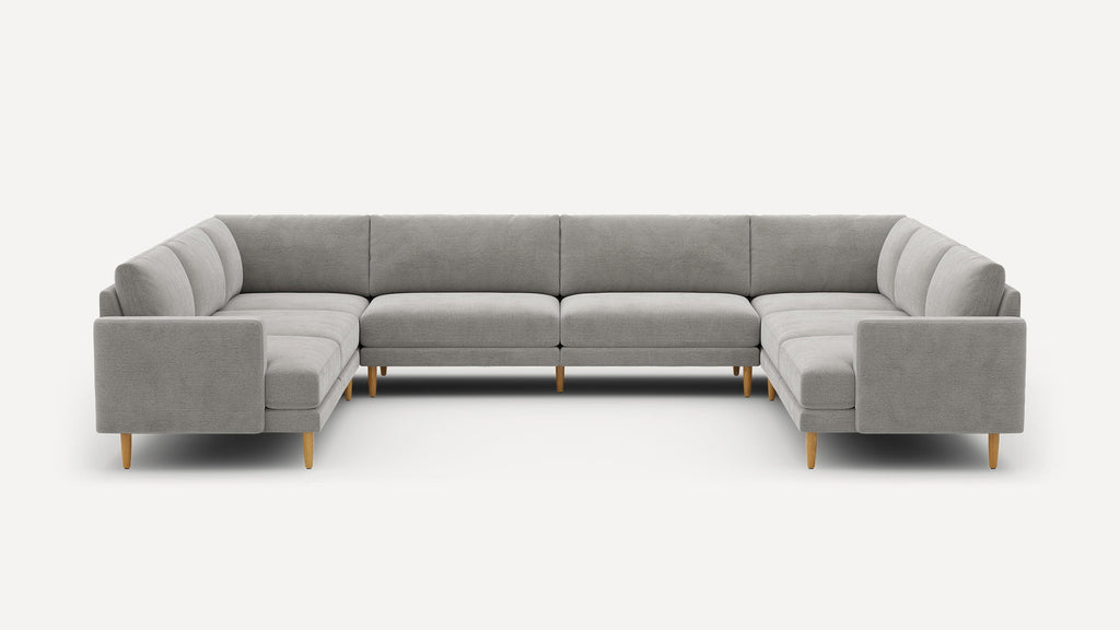 Large modern U-shaped sectional sofa in light gray fabric with wooden legs and minimalist design on white background.