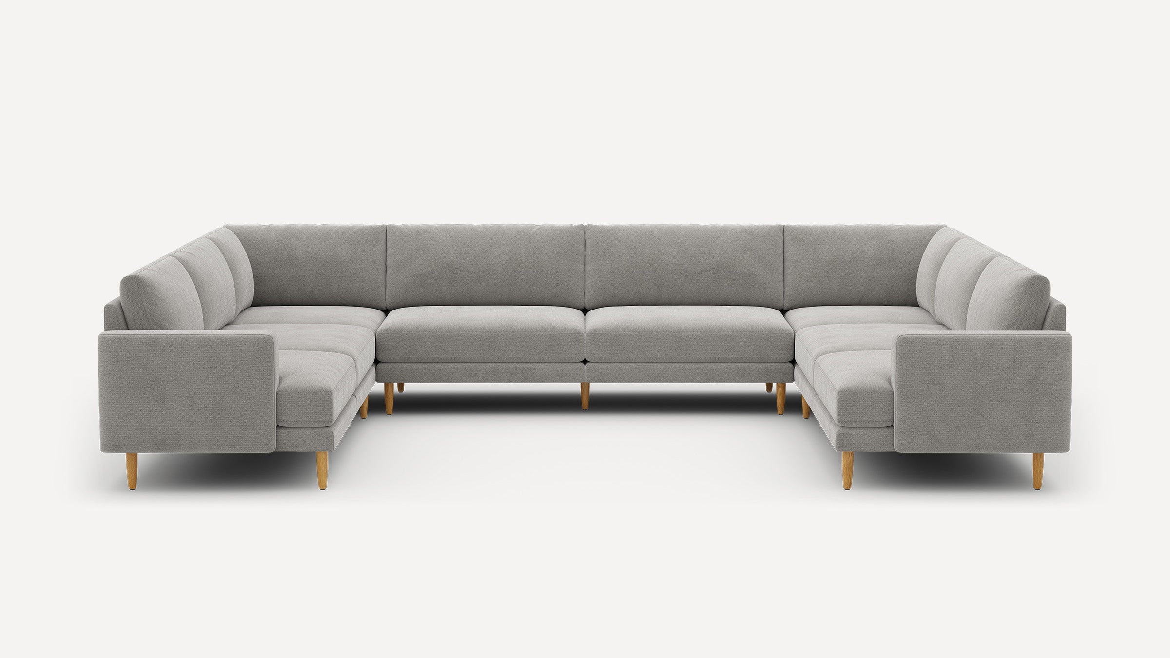 Large modern U-shaped sectional sofa in light gray fabric with wooden legs and minimalist design on white background.