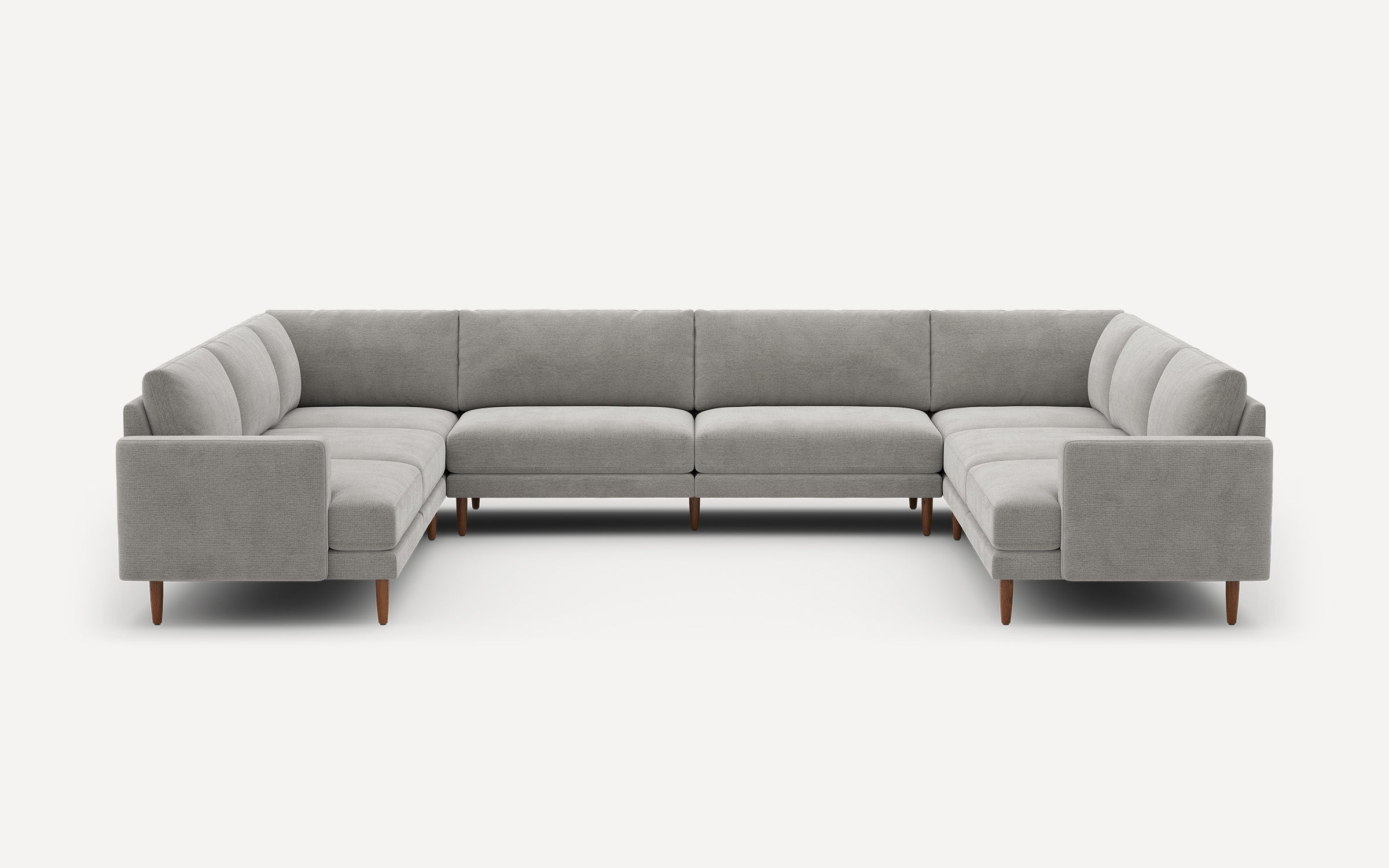 Large modern U-shaped sectional sofa in light gray fabric with wooden legs against a plain white background.