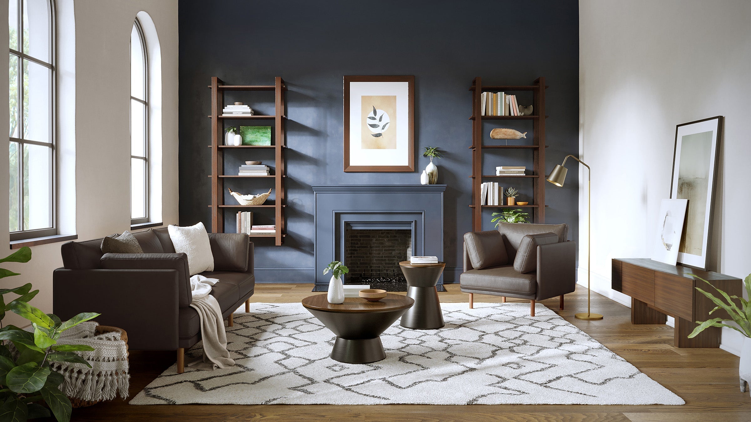 Modern living room with dark brown leather sofa and armchair, geometric patterned rug, wooden coffee tables, and tall windows.