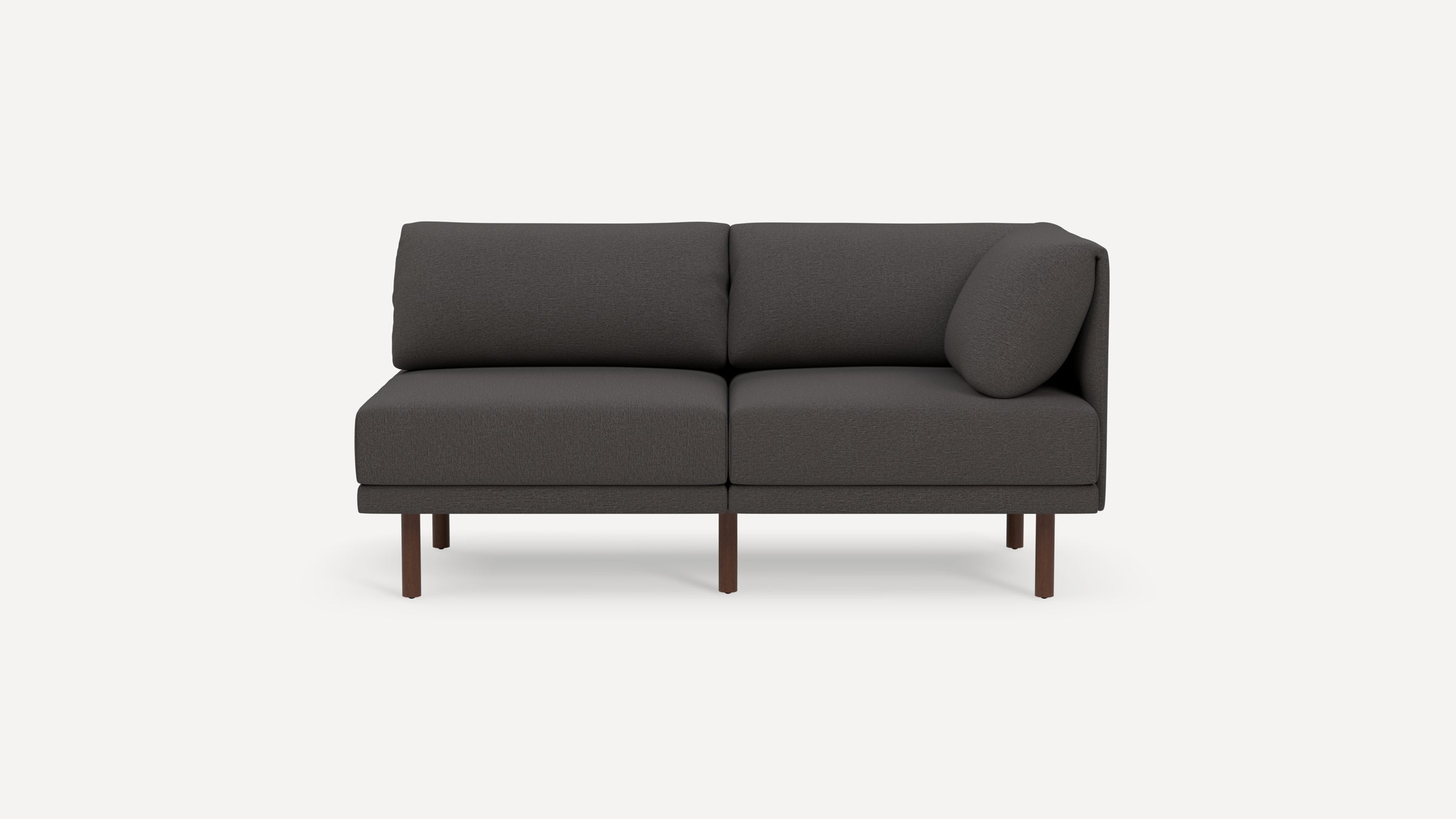 Dark gray modern two-seater sofa with wooden legs and an angled side cushion on a white background.