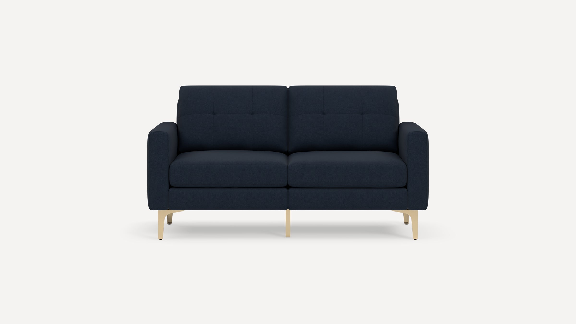 Modern navy blue two-seater sofa with tufted back cushions and sleek light wood legs on a white background.