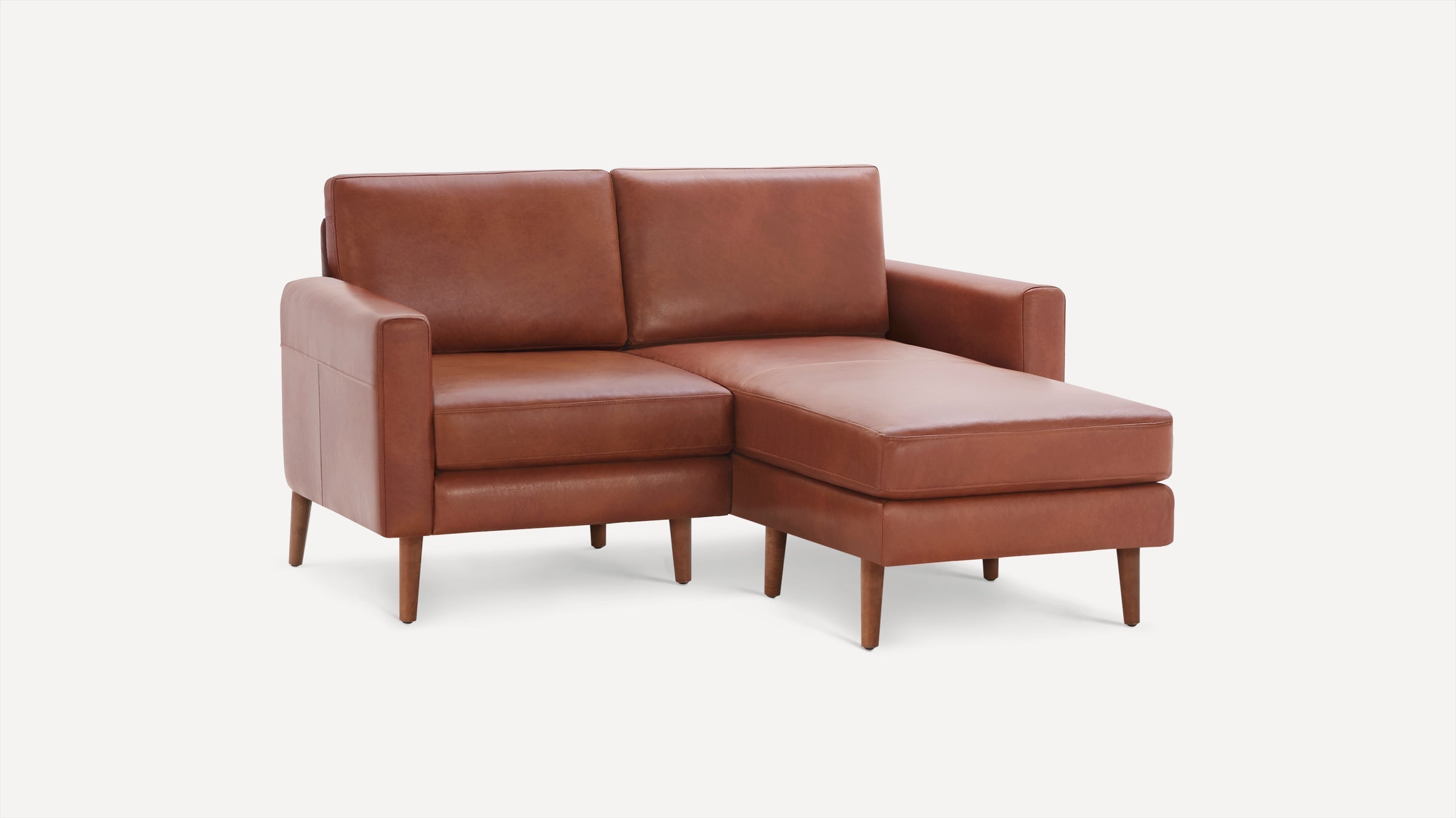 Brown leather sectional sofa with chaise lounge, wooden legs, and clean modern design against white background.