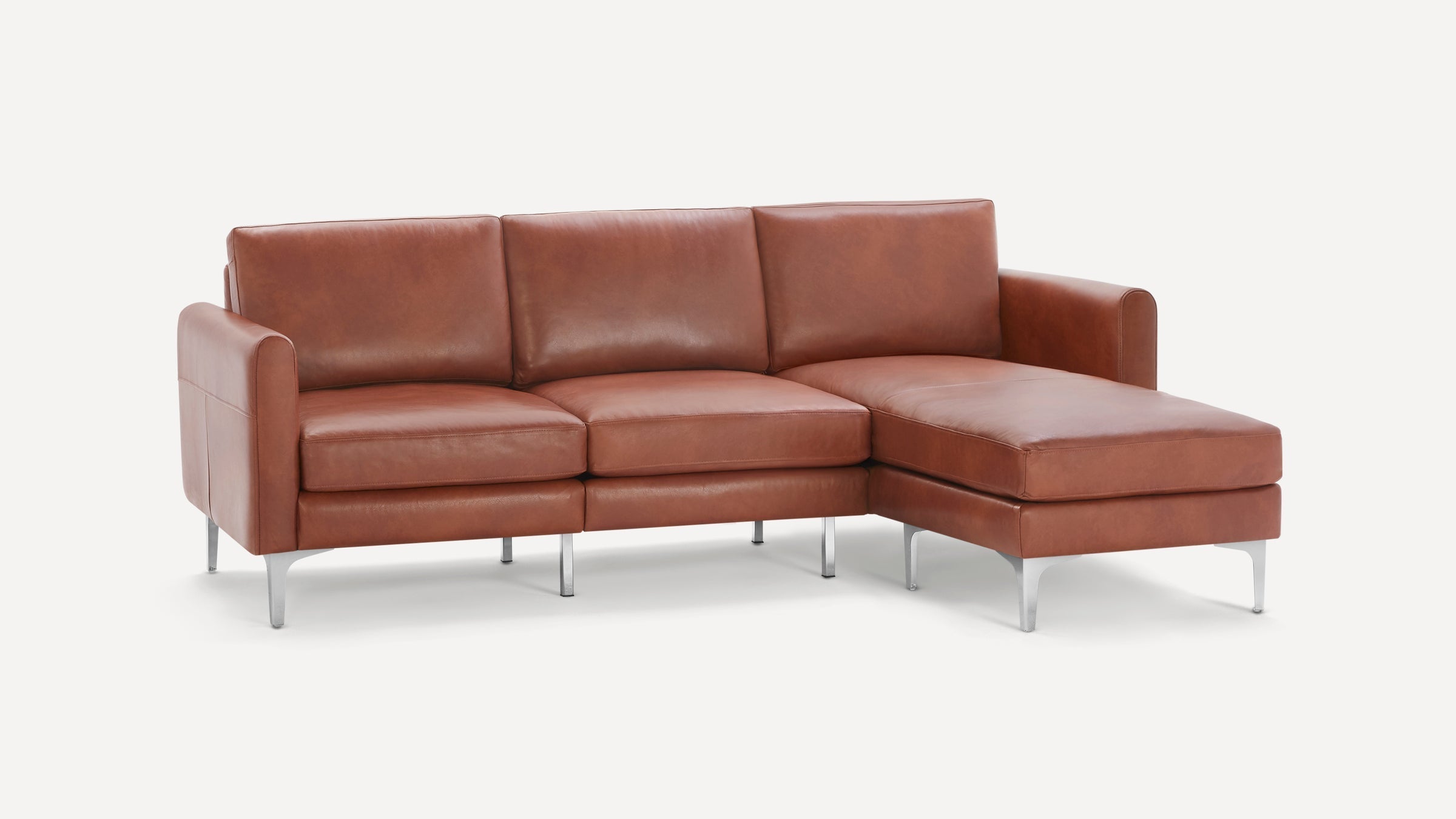 Modern brown leather sectional sofa with three seat cushions, a chaise lounge on the right, and silver metal legs.