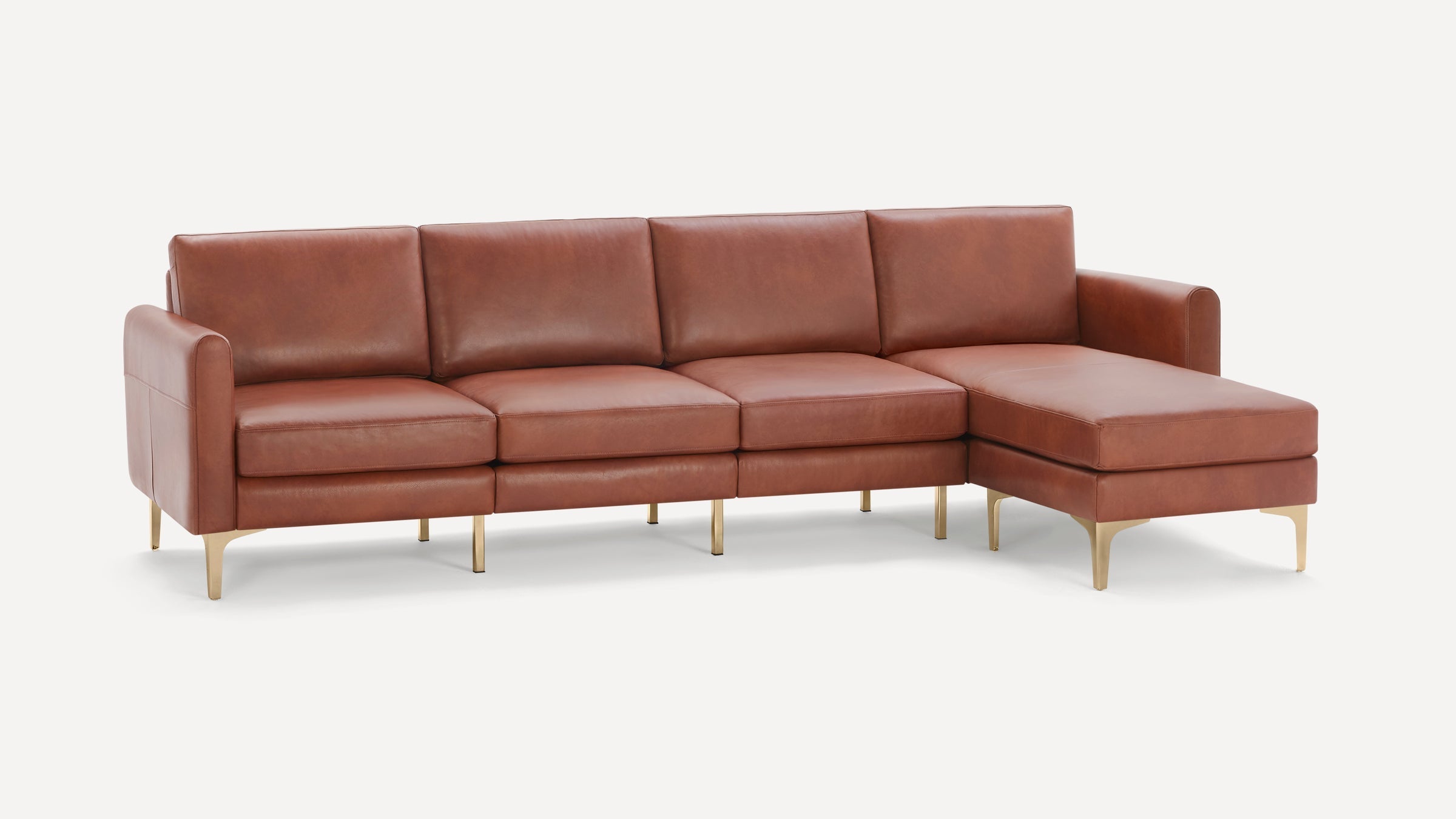 Modern sectional sofa with brown leather upholstery, metal legs, and a chaise lounge on the right side.