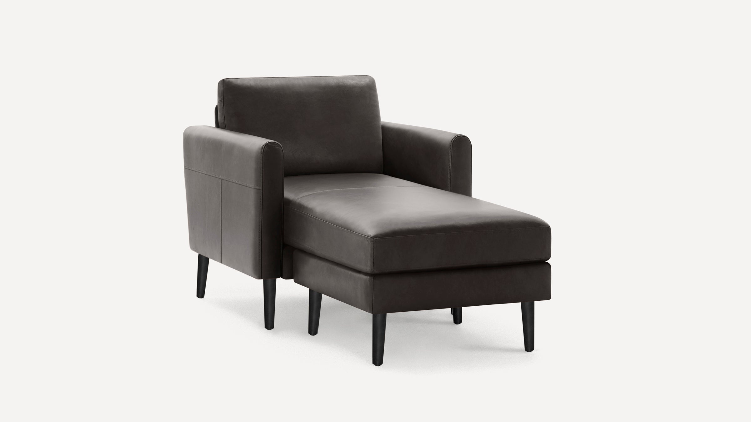 Dark gray leather chaise lounge chair with armrests and black tapered legs on a plain white background.