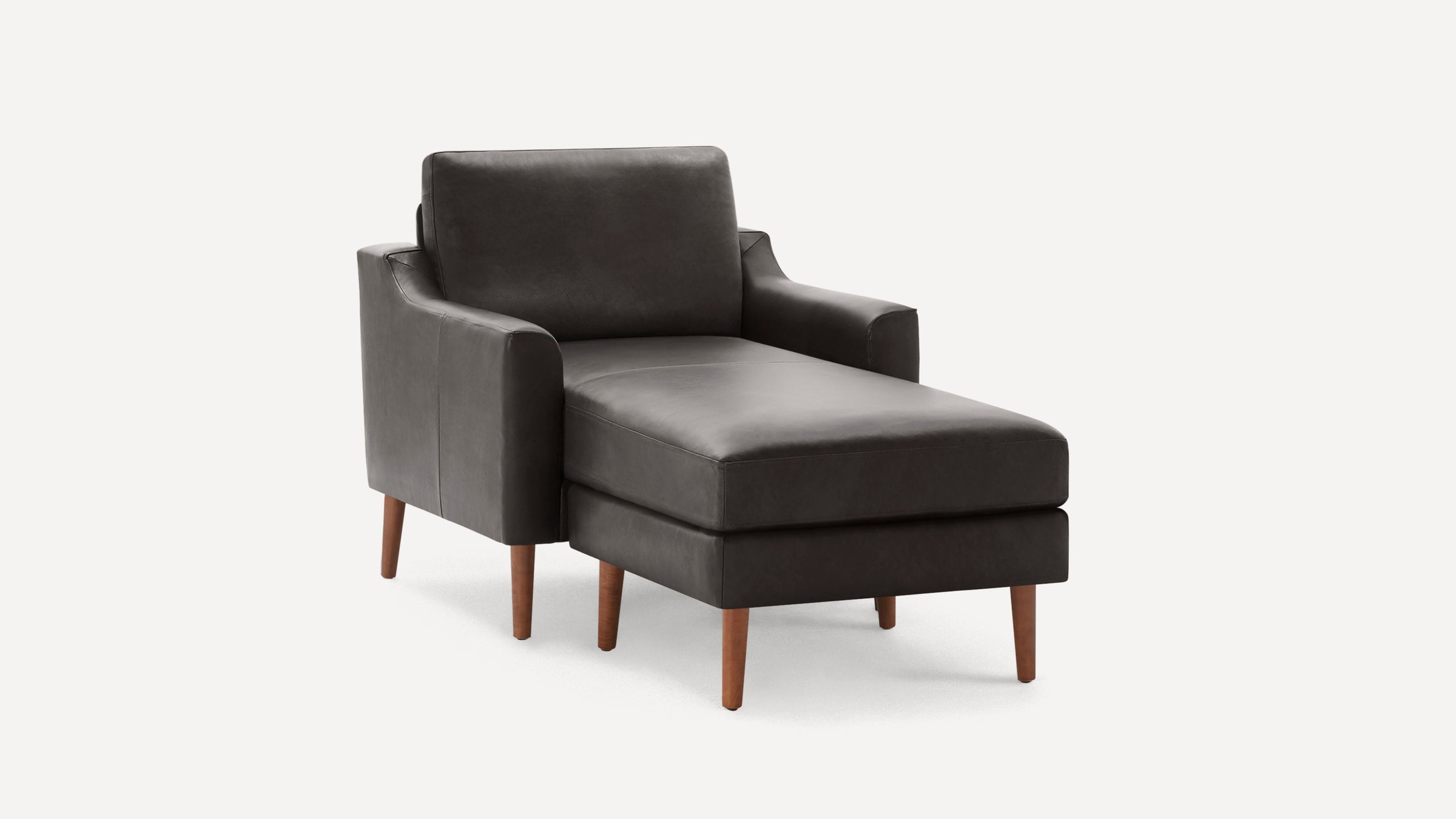Dark brown leather chaise lounge chair with wooden tapered legs and cushioned armrests on a white background.