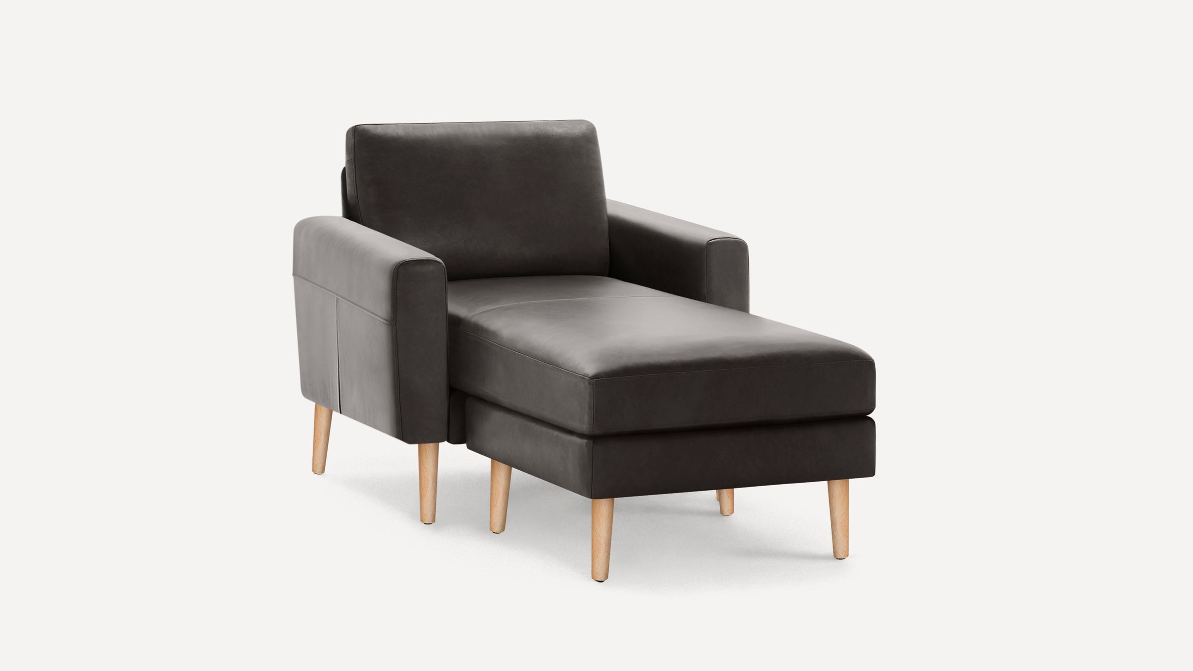 Dark gray leather chaise lounge chair with wooden legs and armrests, set against a white background.