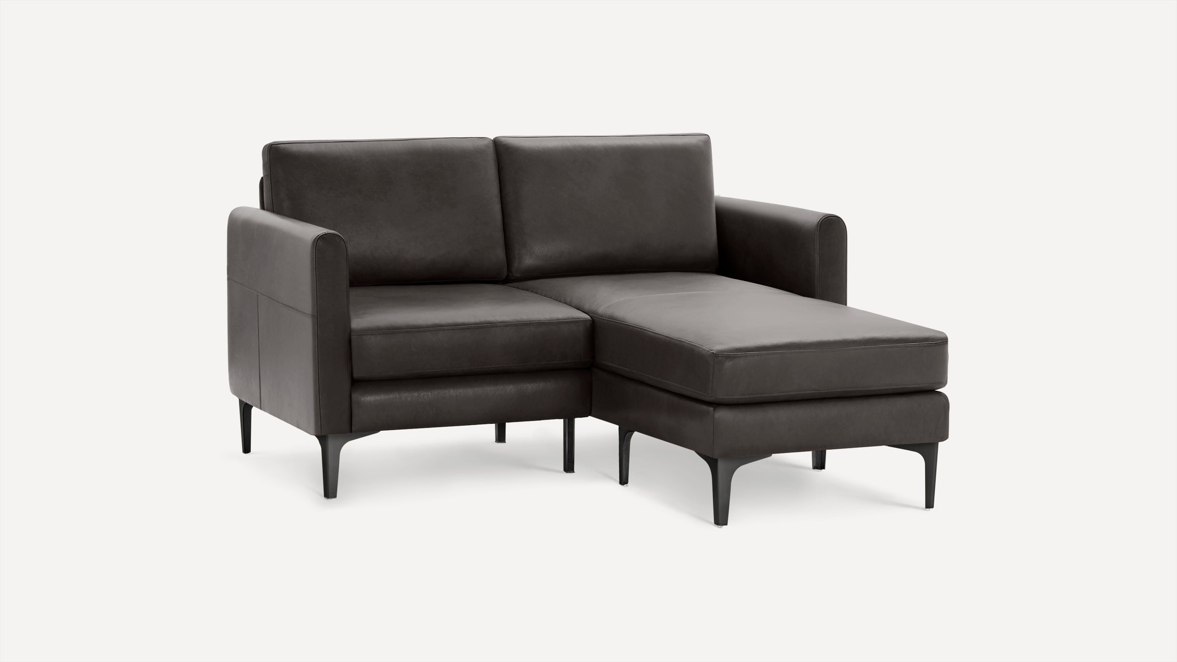Dark gray leather sectional sofa with chaise, sleek design, slim black legs, and clean lines on a white background.