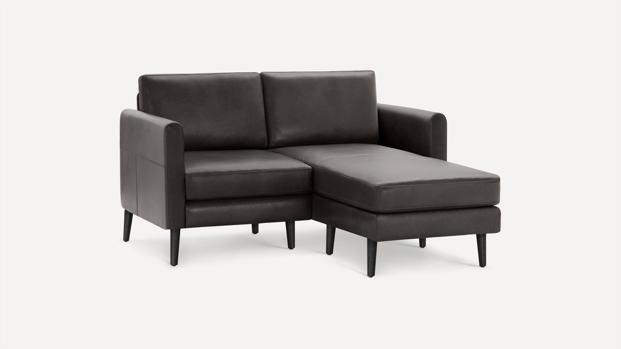 Modern dark gray leather sectional sofa with chaise lounge, clean lines, and tapered black wooden legs on white background.