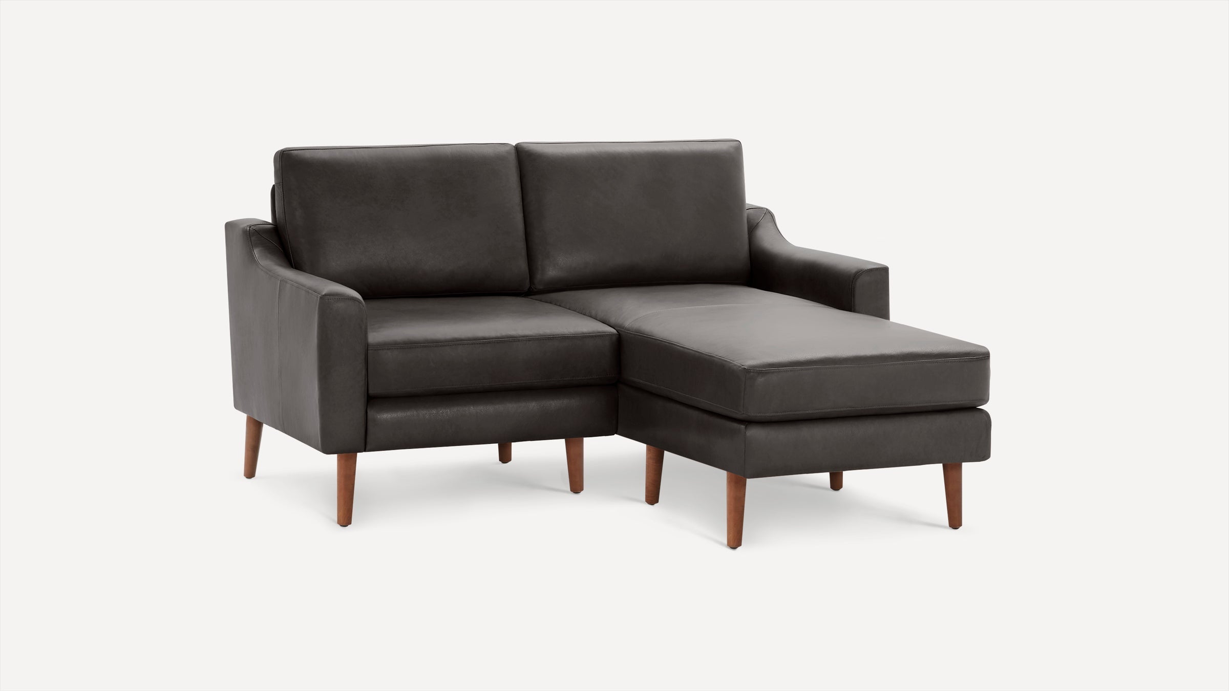 Dark gray leather sectional sofa with chaise lounge, featuring wooden tapered legs and clean, modern lines.
