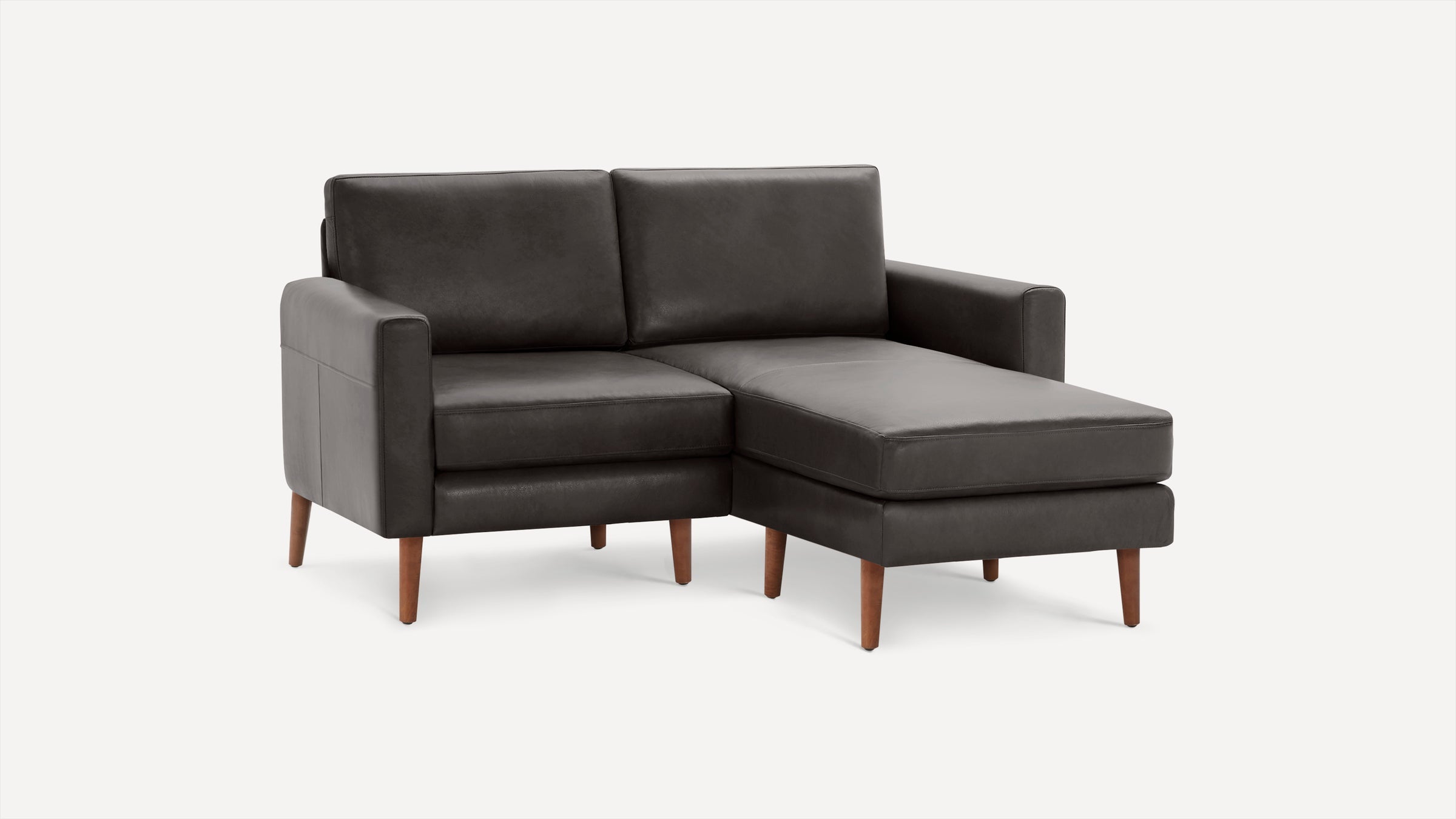 Dark grey leather sectional sofa with clean lines, wooden tapered legs, and chaise lounge on the right side.