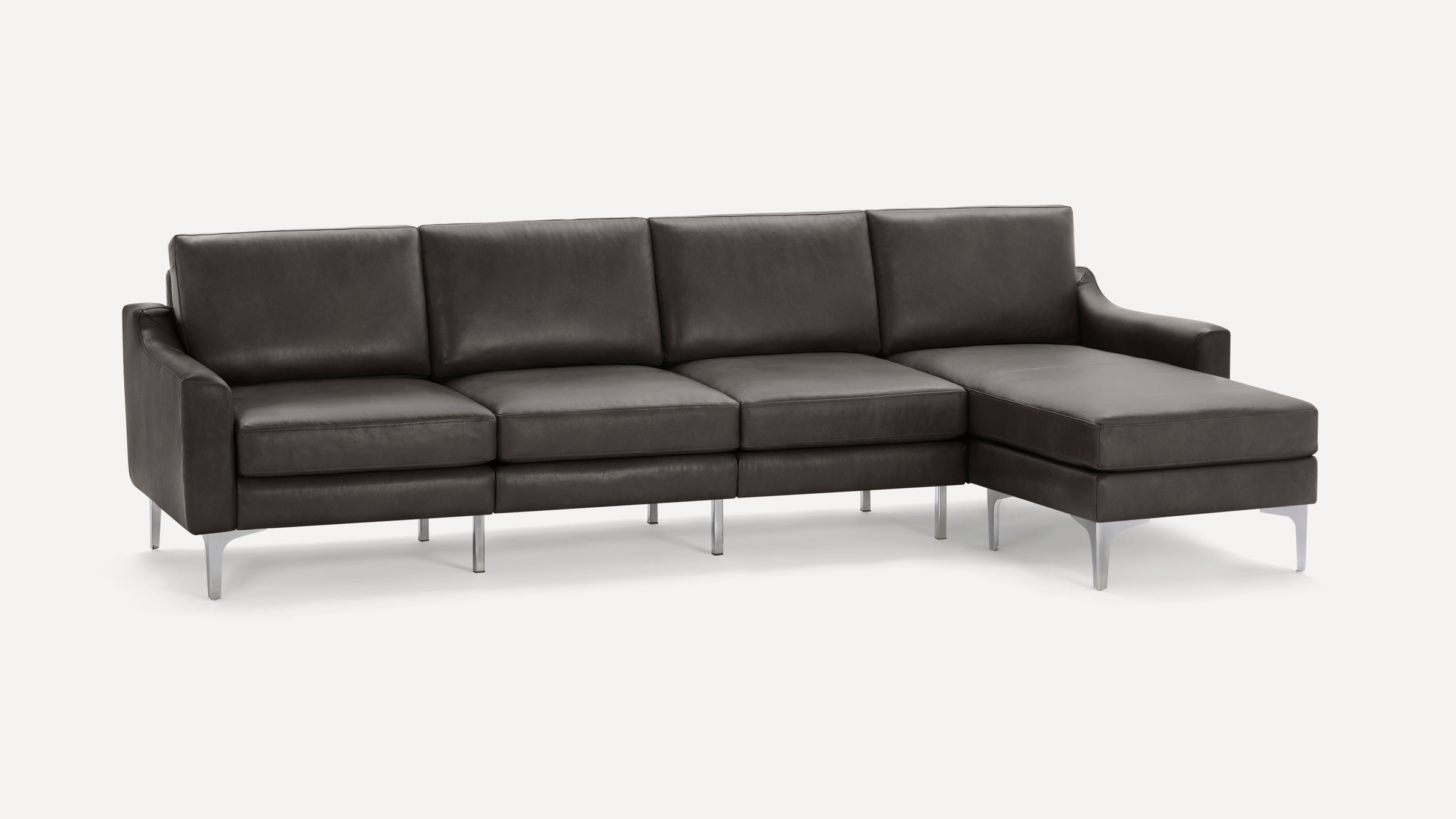 Grey leather sectional sofa with chaise lounge on the right side, supported by slim metallic legs.