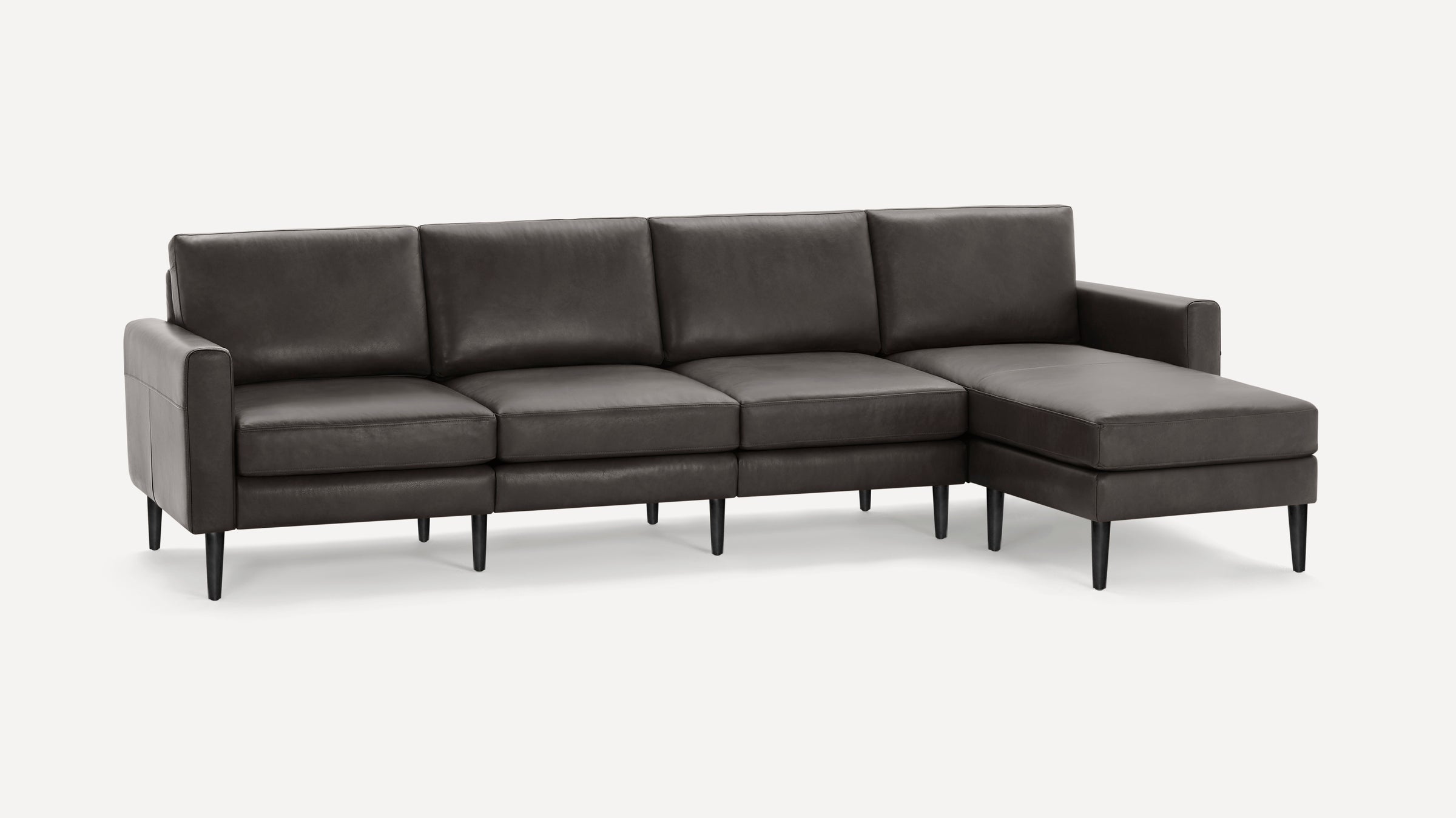 Dark gray modern sectional sofa with sleek cushions, straight armrests, and tapered black legs on a white background.