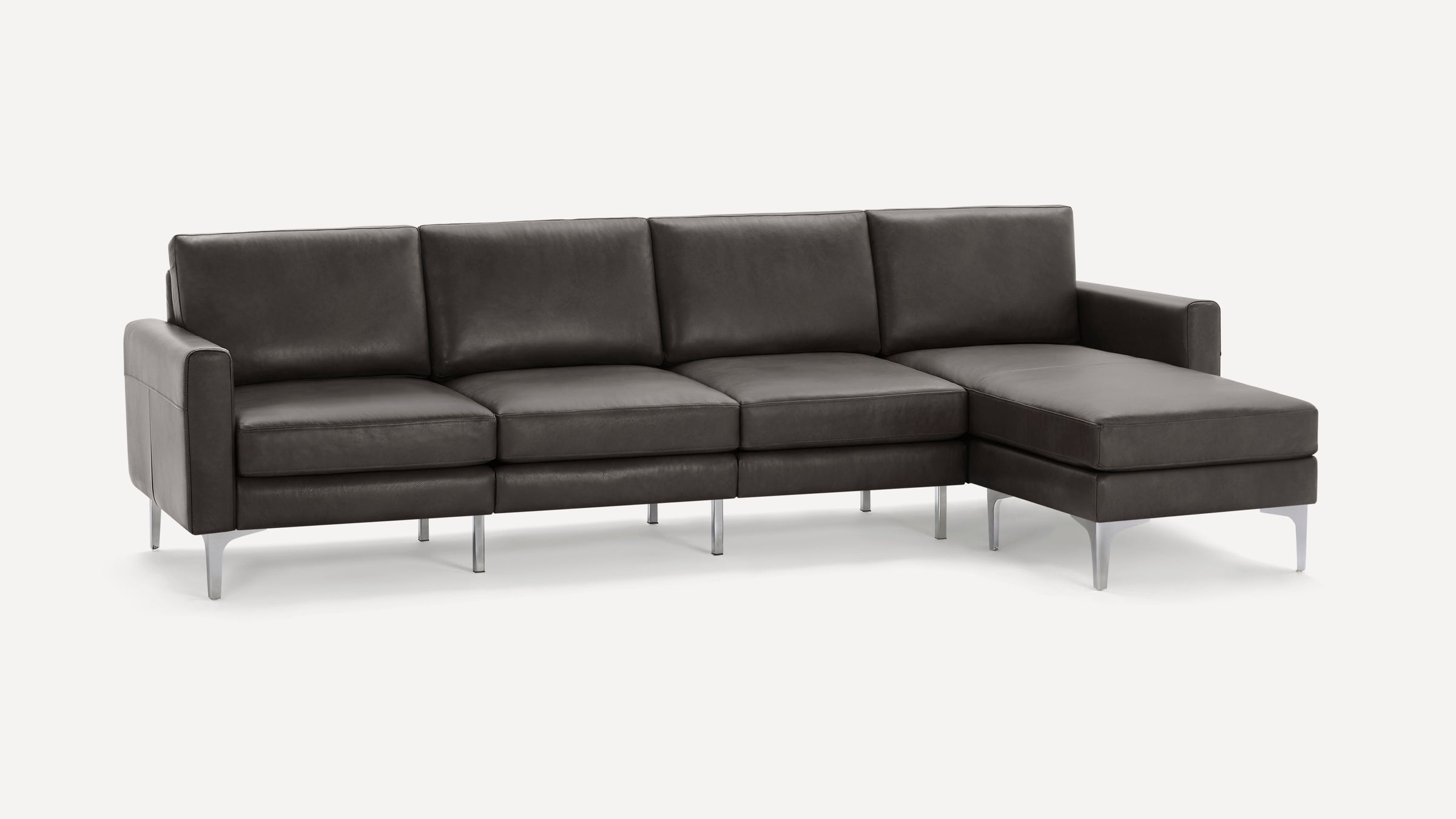 Modern dark gray leather sectional sofa with metal legs, featuring a chaise lounge on the right side.
