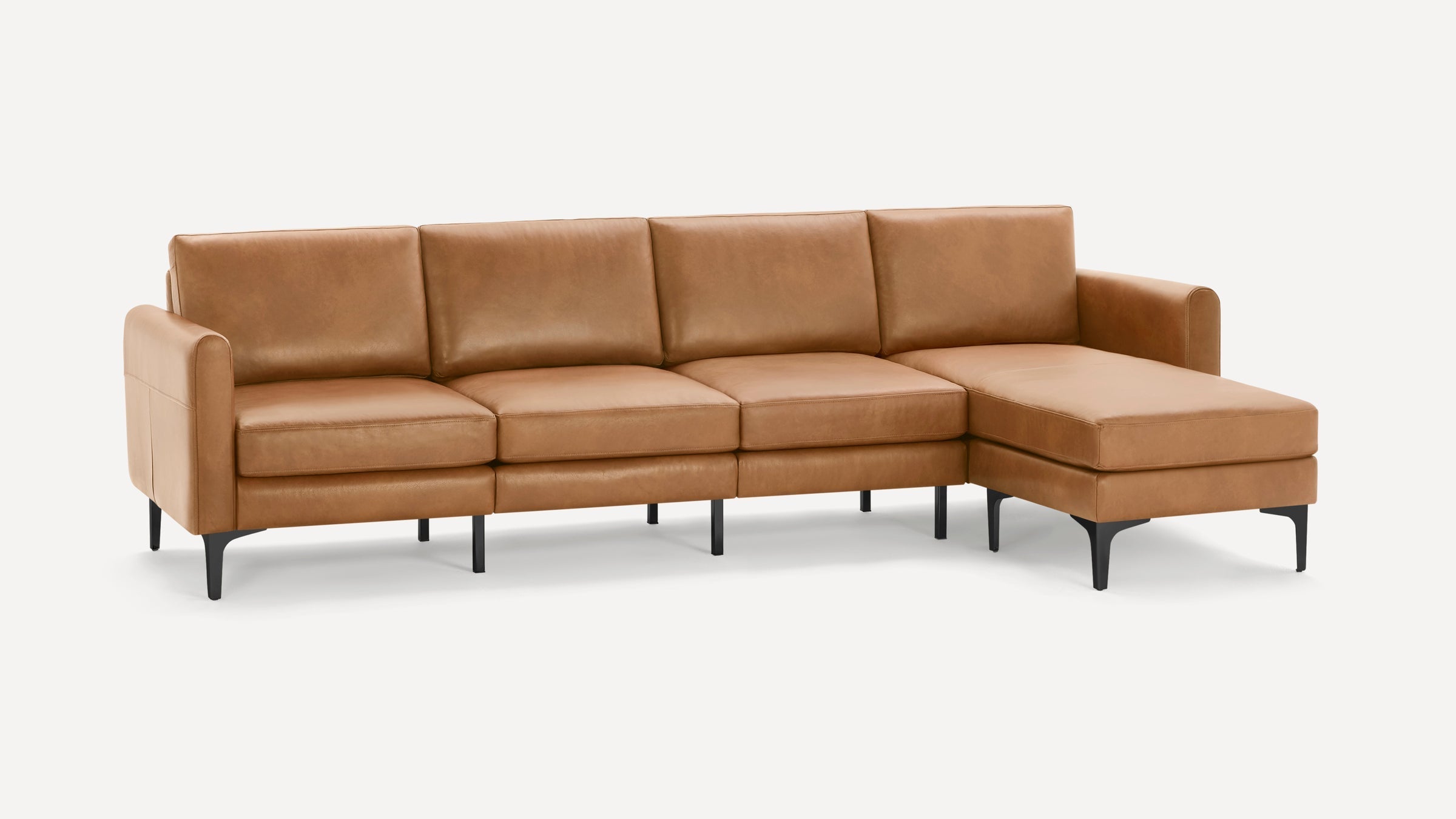 Modern tan leather sectional sofa with black metal legs, featuring three seats and a chaise lounge on the right side.