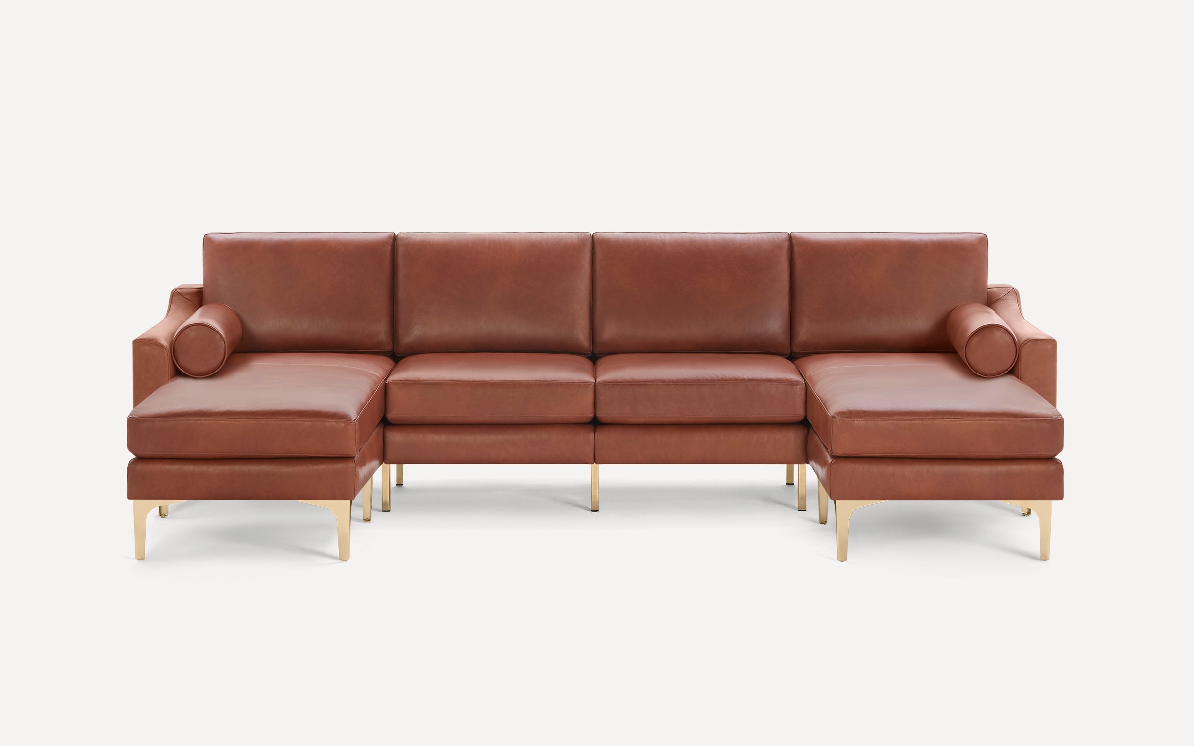 Brown leather sectional sofa with gold metal legs, featuring two chaise lounges and cylindrical bolster pillows on each side.
